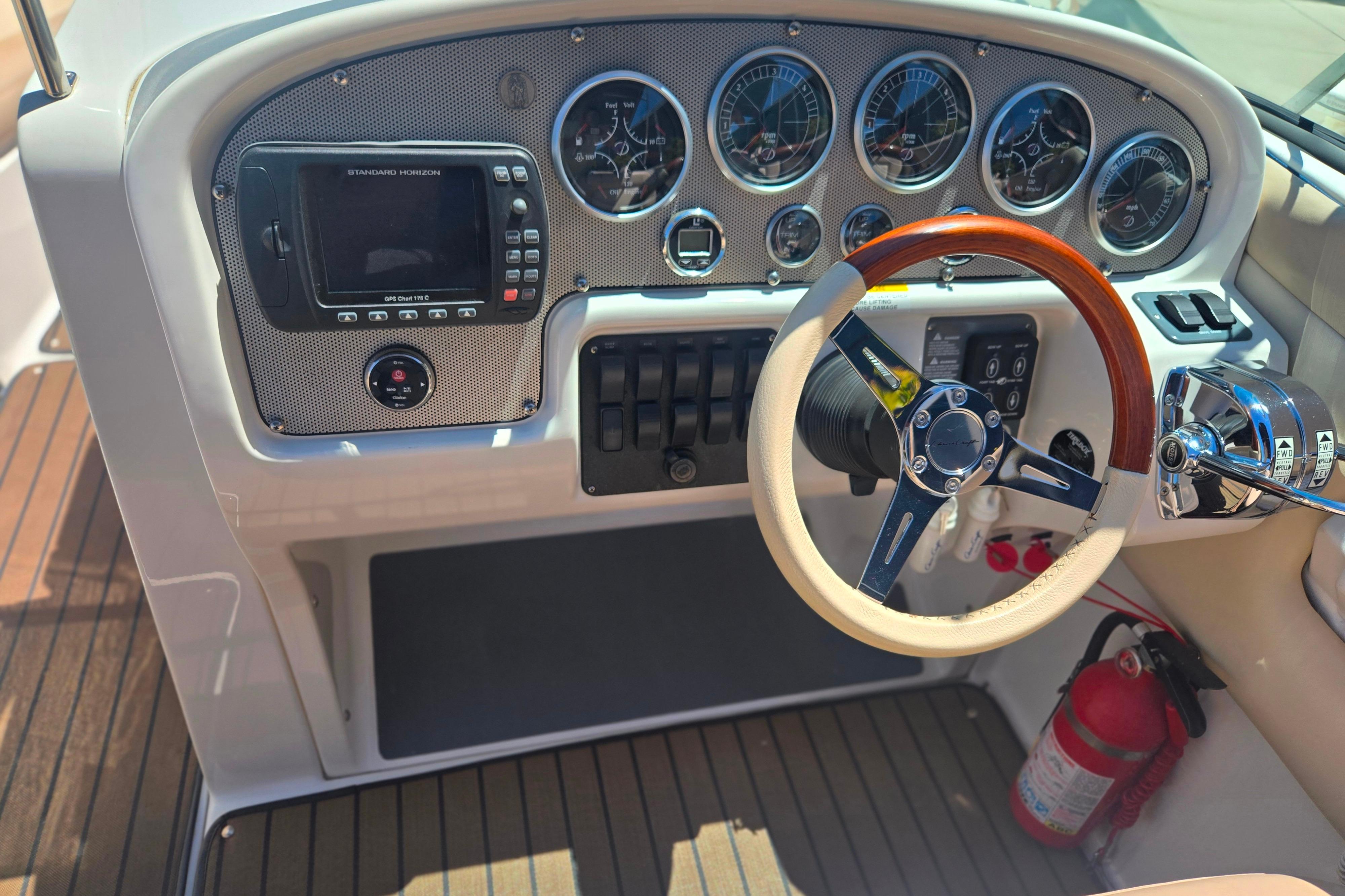 Dashboard of a 2002 Chris-Craft Launch 28 GT I/O with gauges and wooden steering wheel.