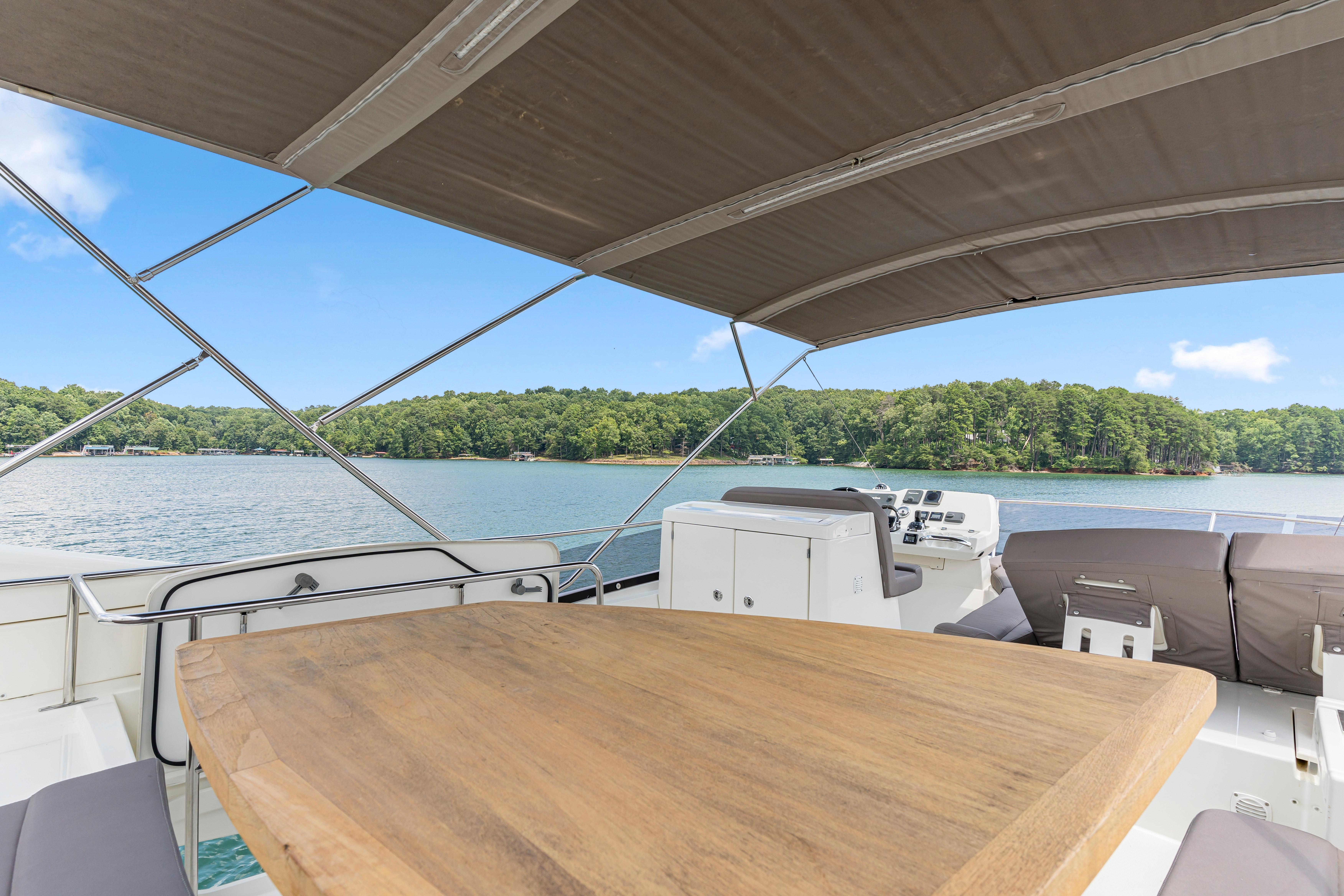 Luxury 2017 Prestige 500 yacht with spacious deck and scenic lake view.