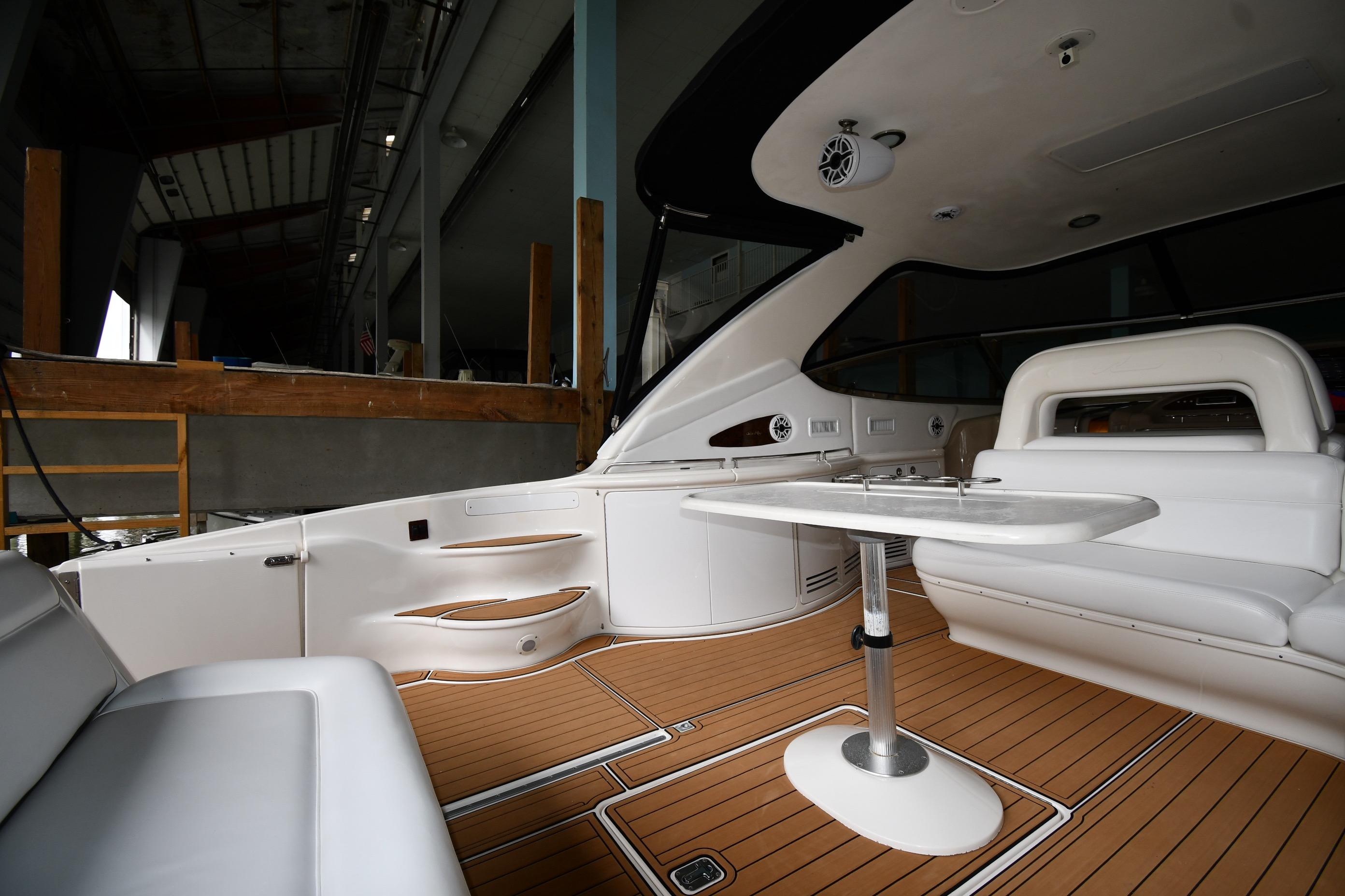 Luxurious interior of 2001 Sea Ray 540 Sundancer yacht with white seating and wooden flooring.