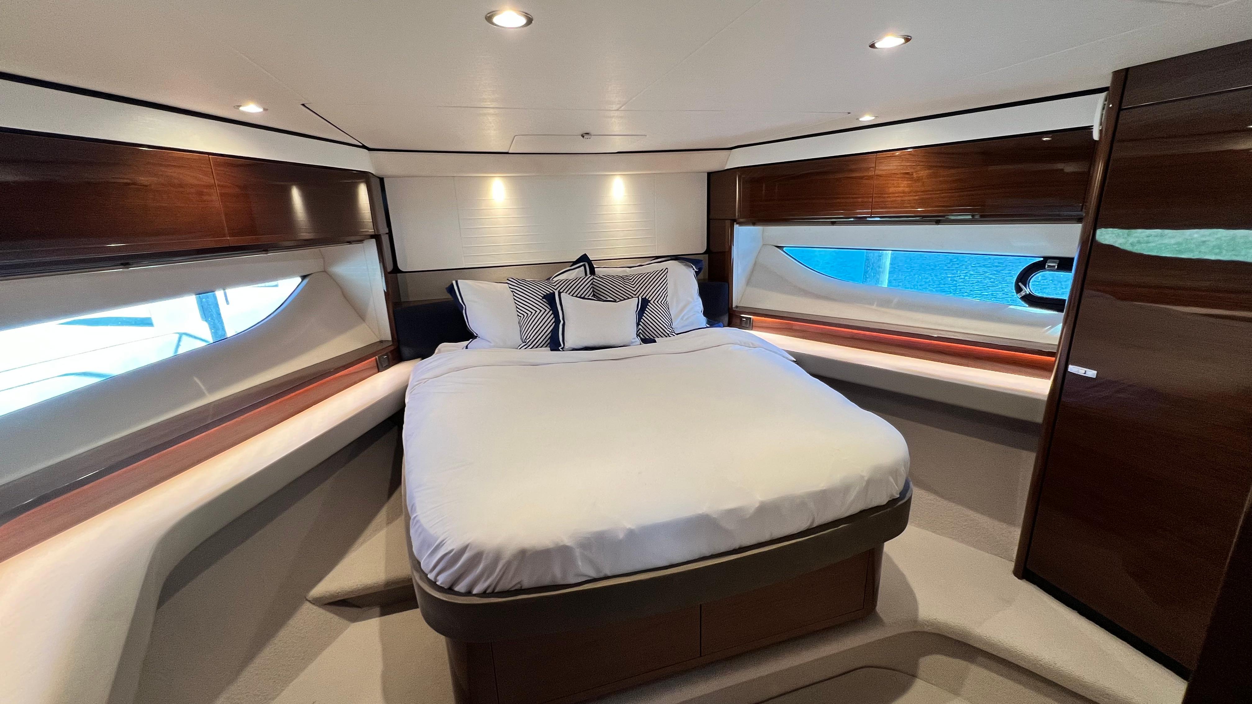 Luxurious bedroom interior of 2019 Princess F62 yacht with elegant wood finishes.