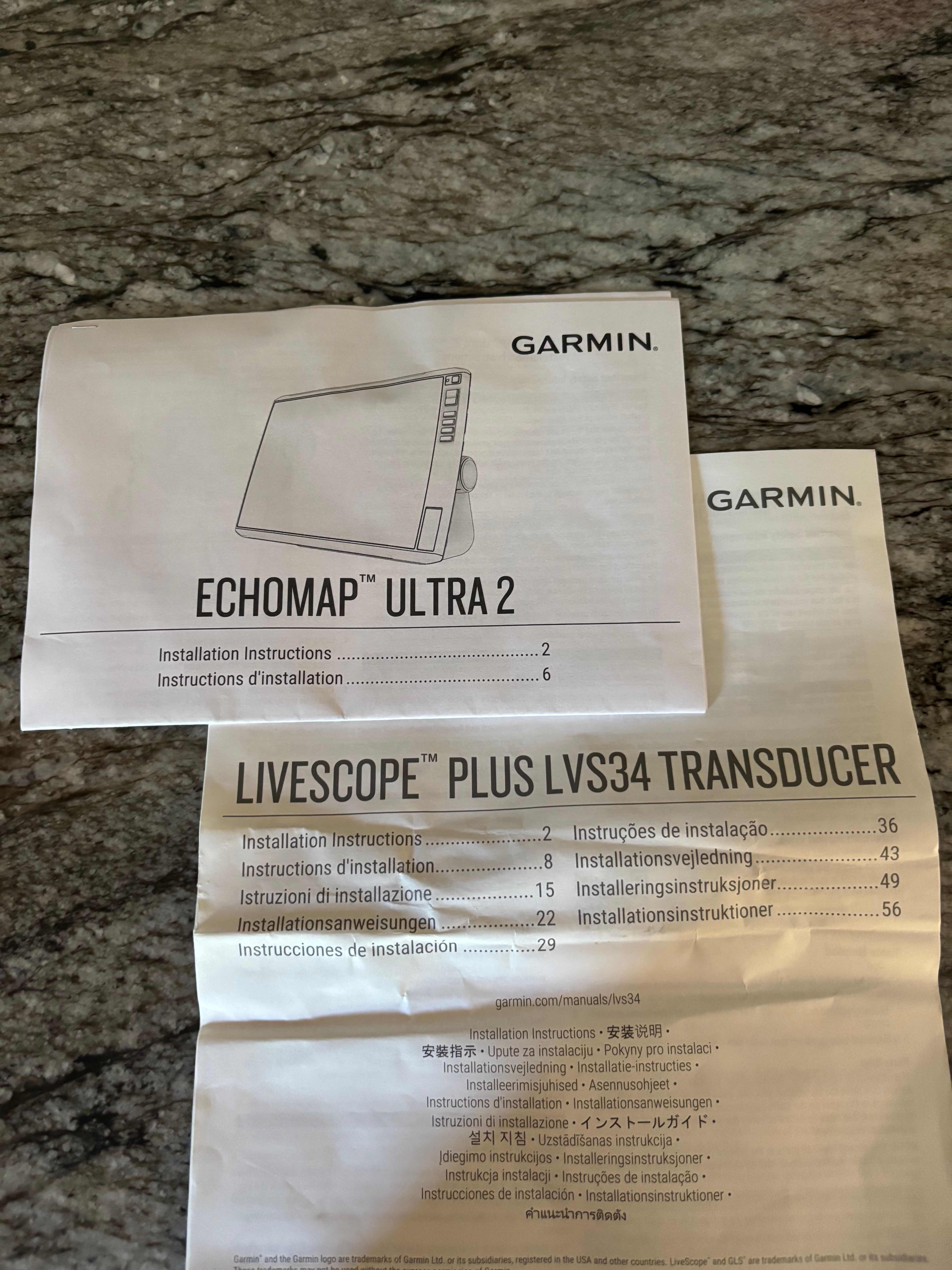 Garmin Echomap Ultra 2 and Livescope Plus LVS34 Transducer manuals on a table.