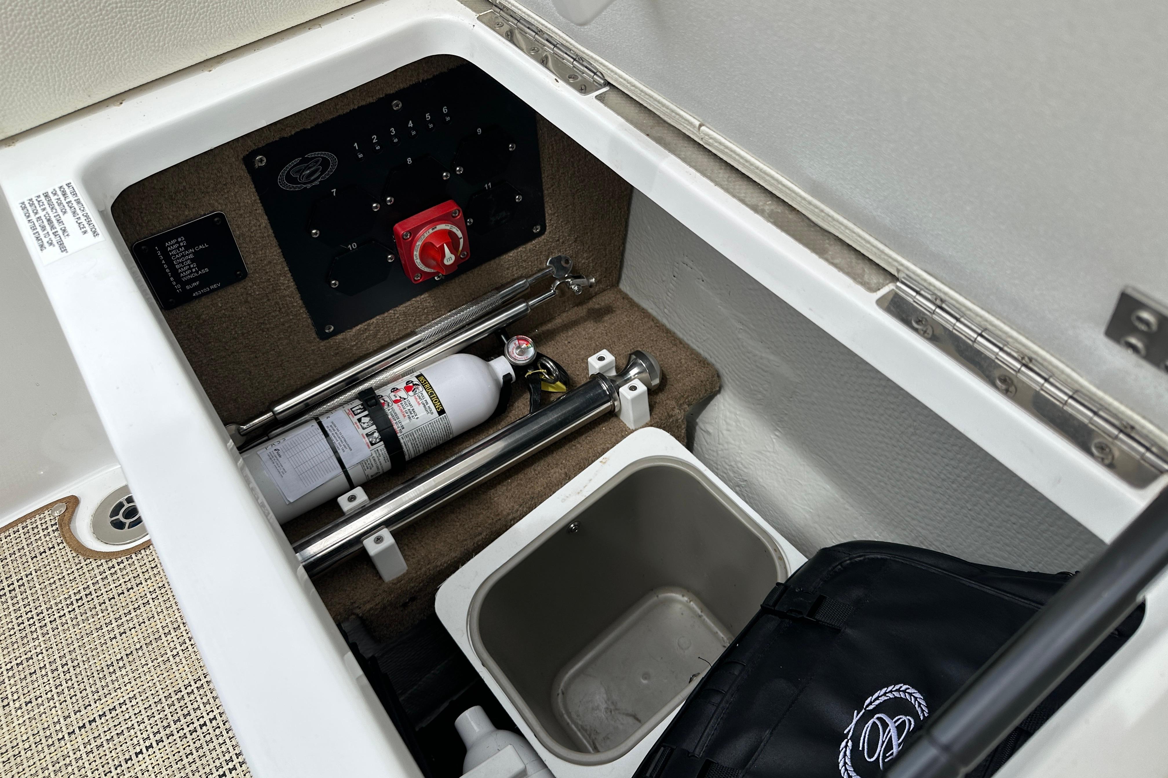 2019 Cobalt R5 boat storage compartment with fire extinguisher and control panel.