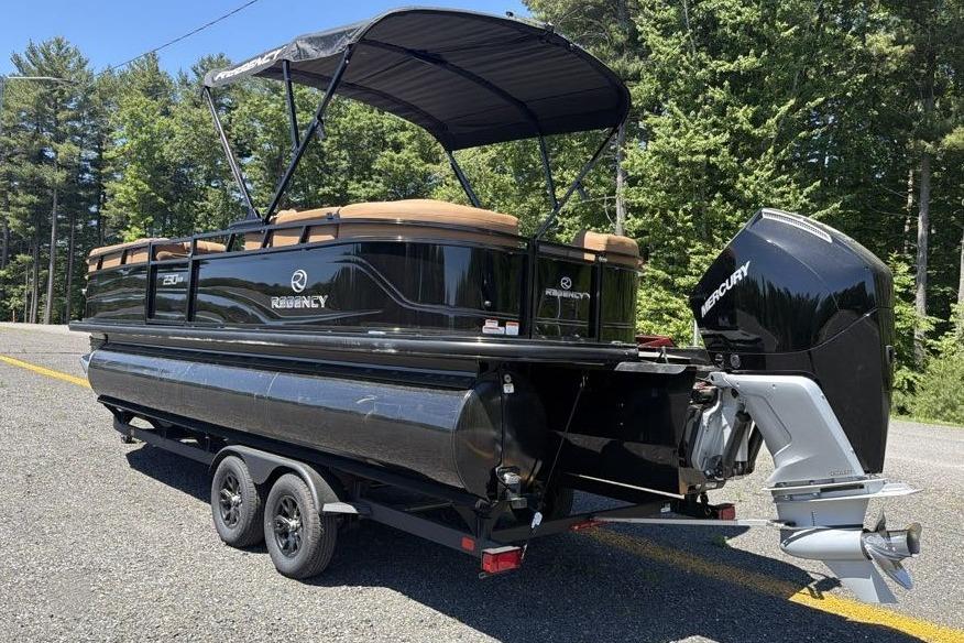 2026 Regency 230 DL pontoon boat with Mercury outboard motor on trailer, parked outdoors.