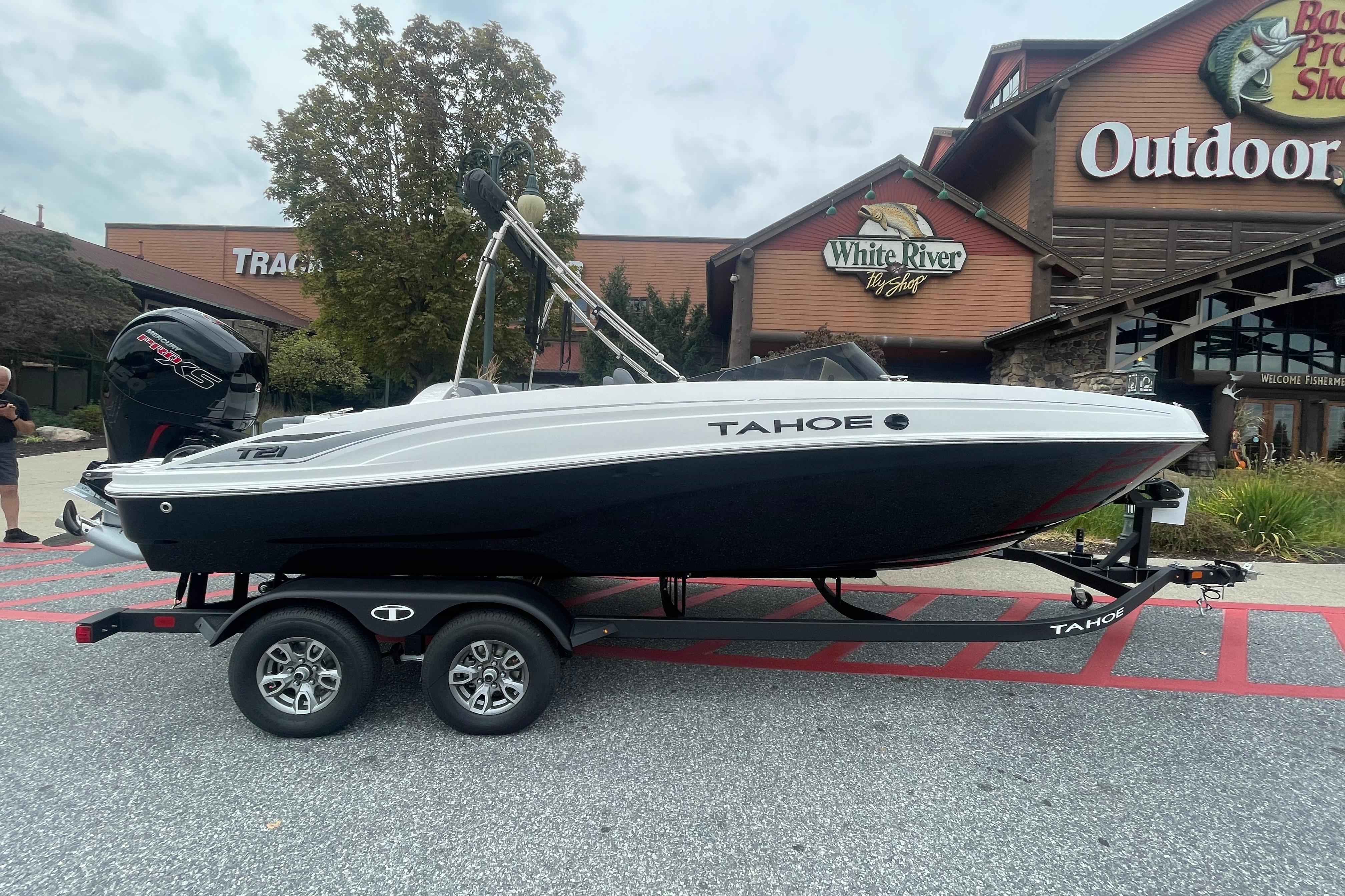 2026 Tahoe T21 boat on trailer outside outdoor shop.