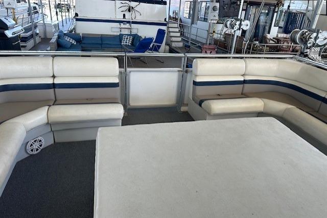 Spacious seating area on 2008 Destination Yachts 45X14 houseboat with white and blue upholstery.