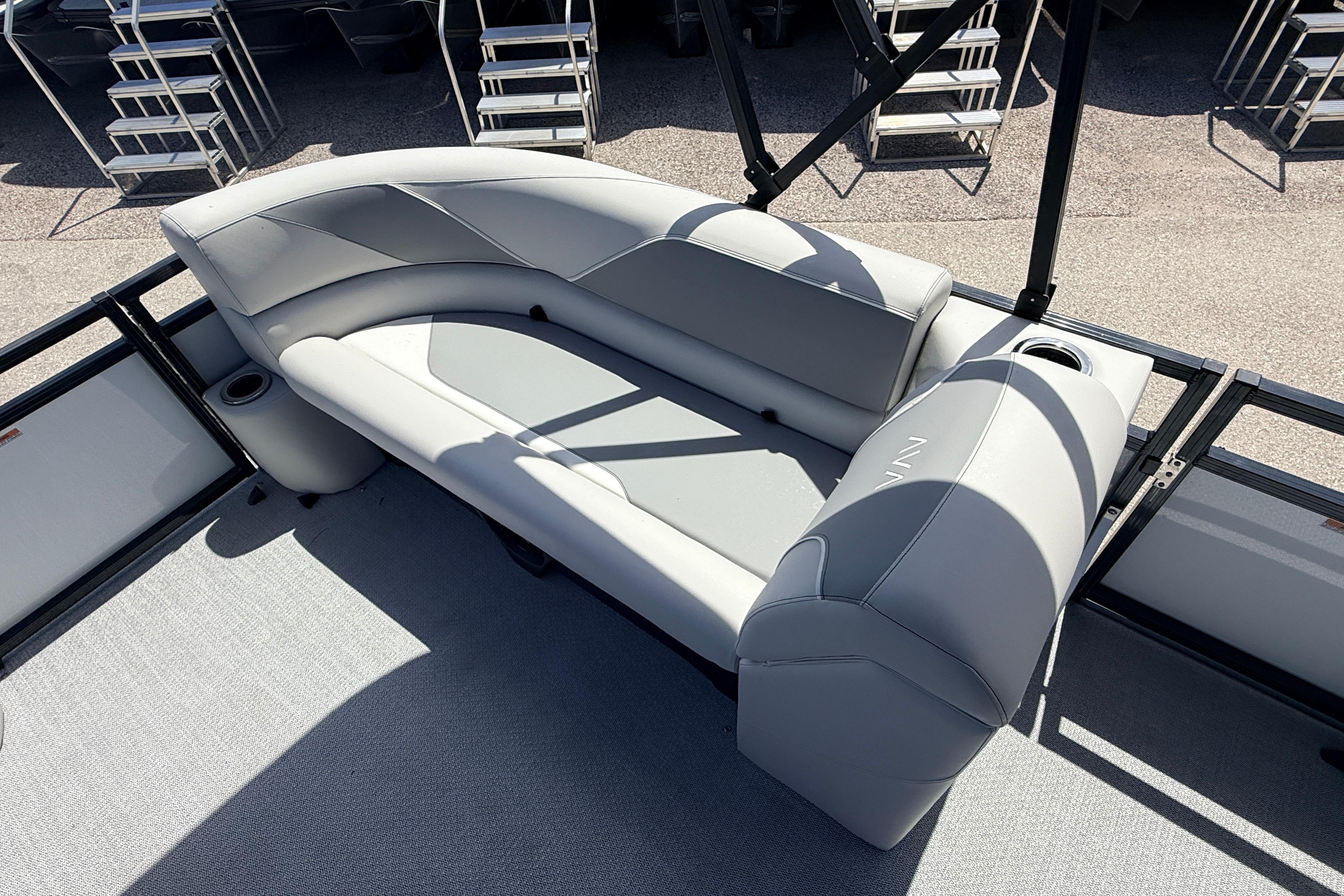2026 Avalon 2385 Venture 85 Tri Toon boat with sleek gray seating and cup holders.