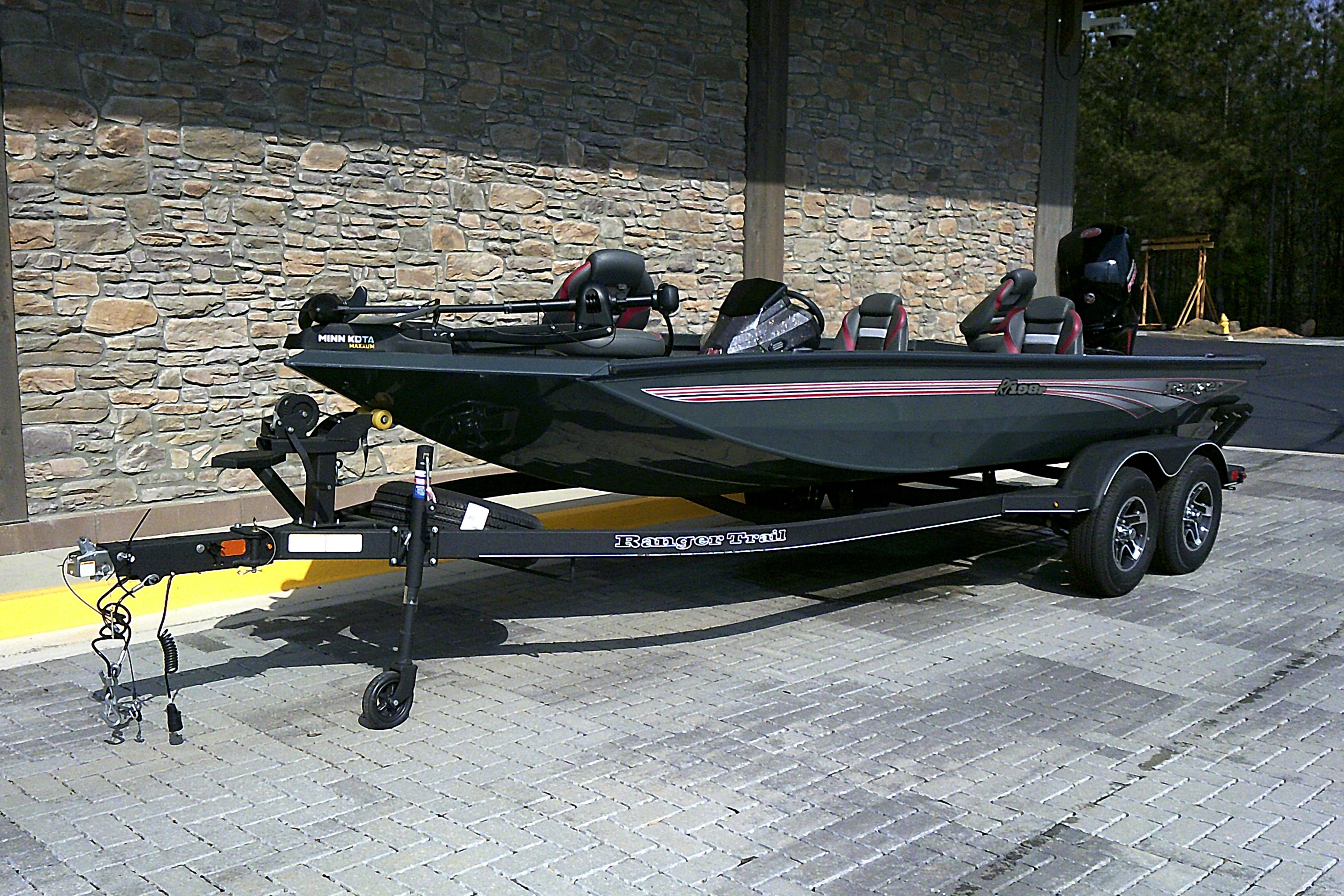 2025 Ranger RT198P boat on trailer, parked on paved surface near stone wall.