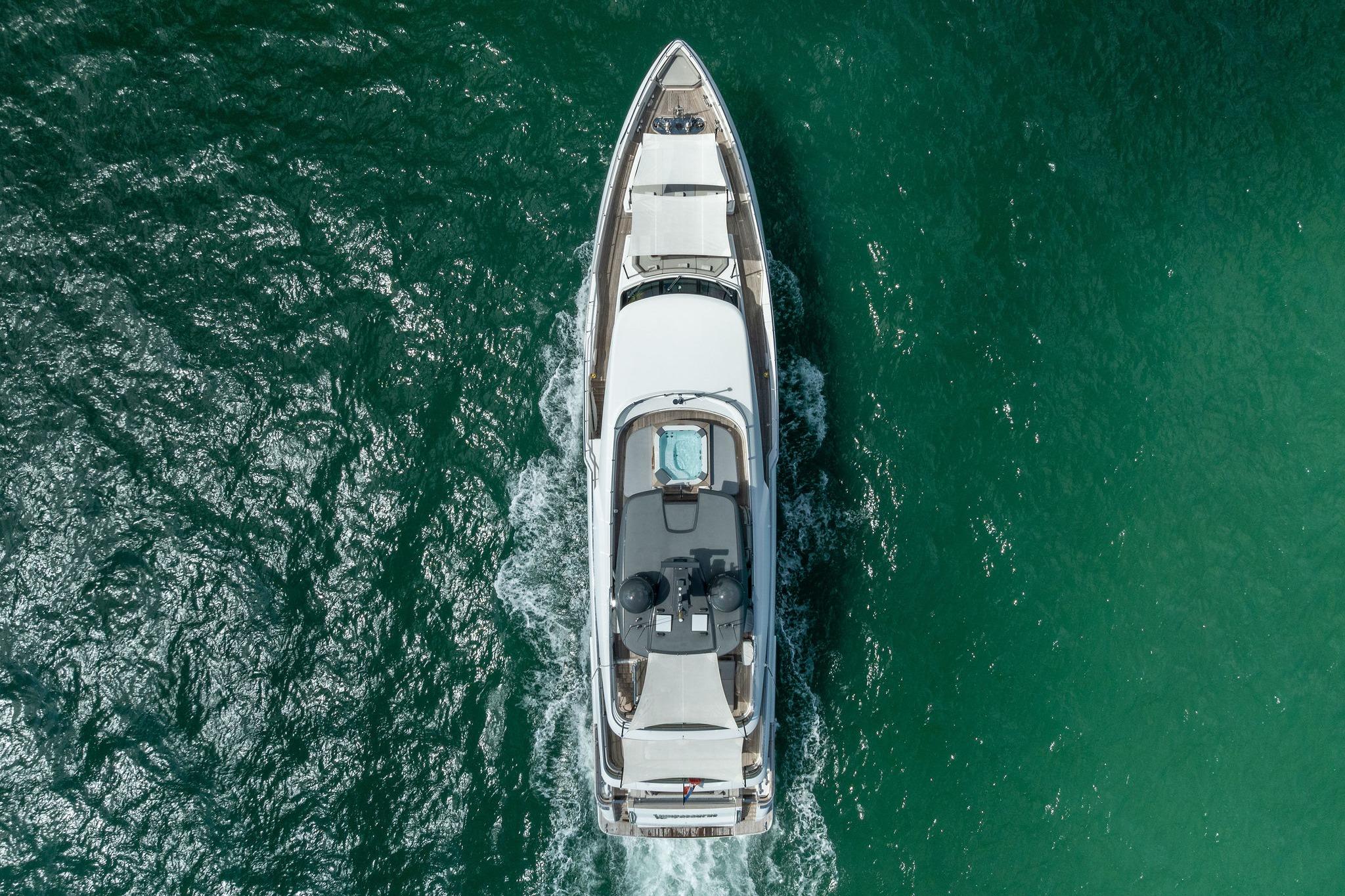 Aerial view of 2023 Custom Line Navetta 33 yacht cruising in clear blue waters.