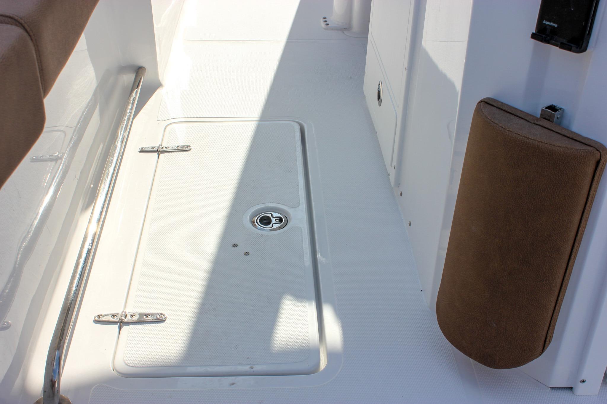 Deck view of 2027 Sea Hunt Ultra 275 SE, featuring storage hatch and cushioned side panel.