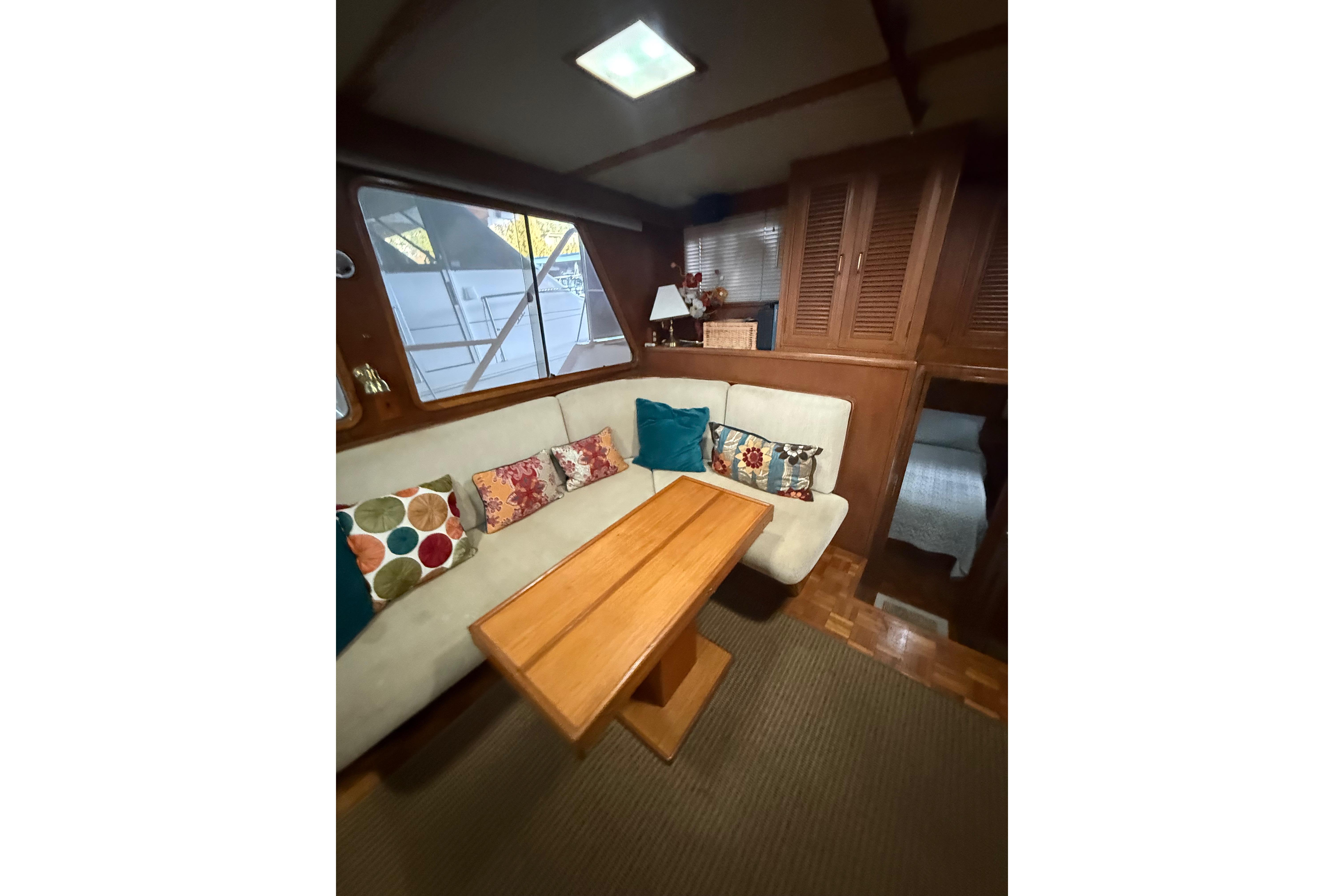 Interior of 1983 Ocean Alexander 43 Flush Aft Deck with cozy seating and colorful pillows.