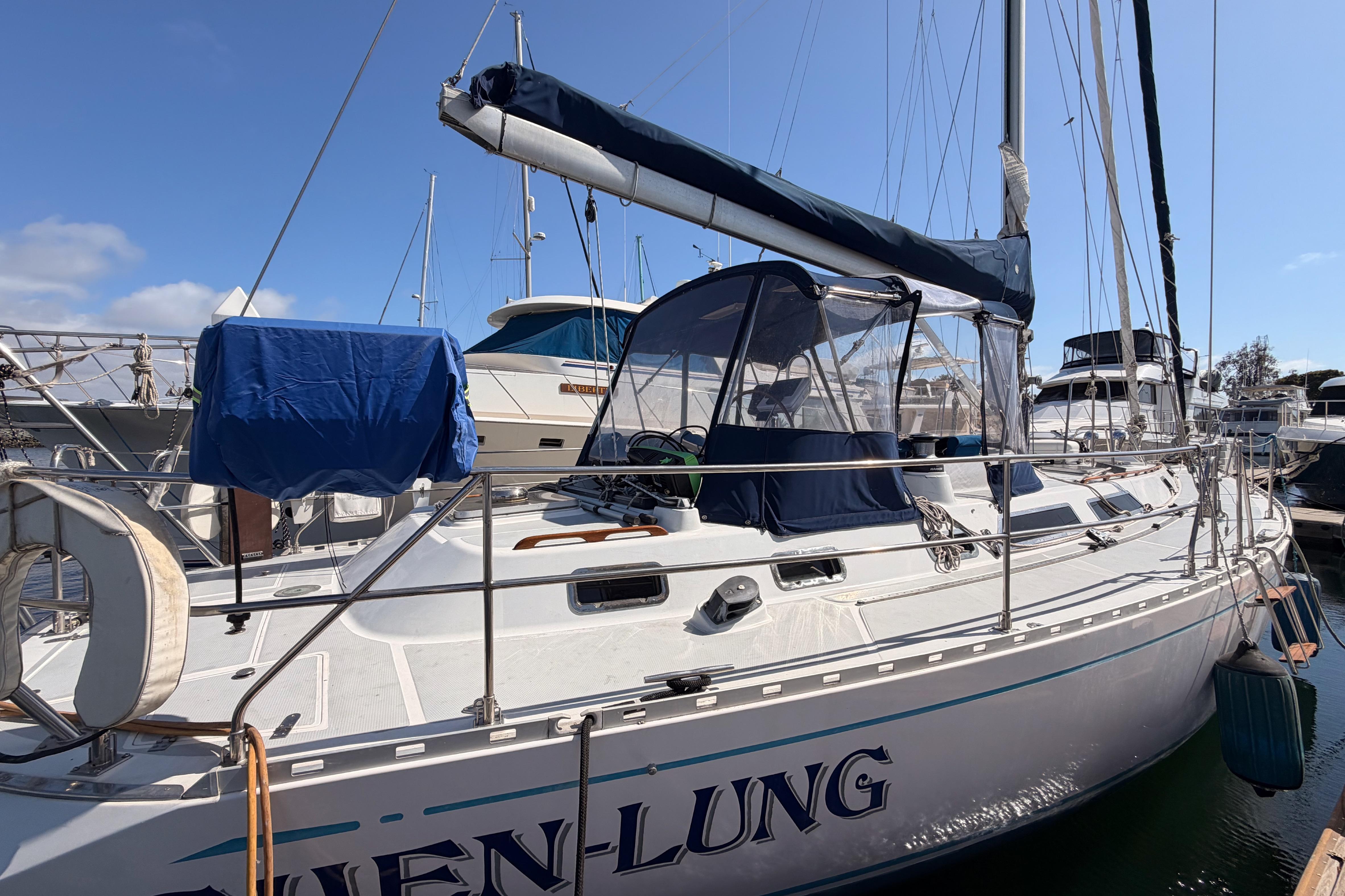 Sailboat docked at marina, Hylas 51 model from 1991, under clear blue sky.