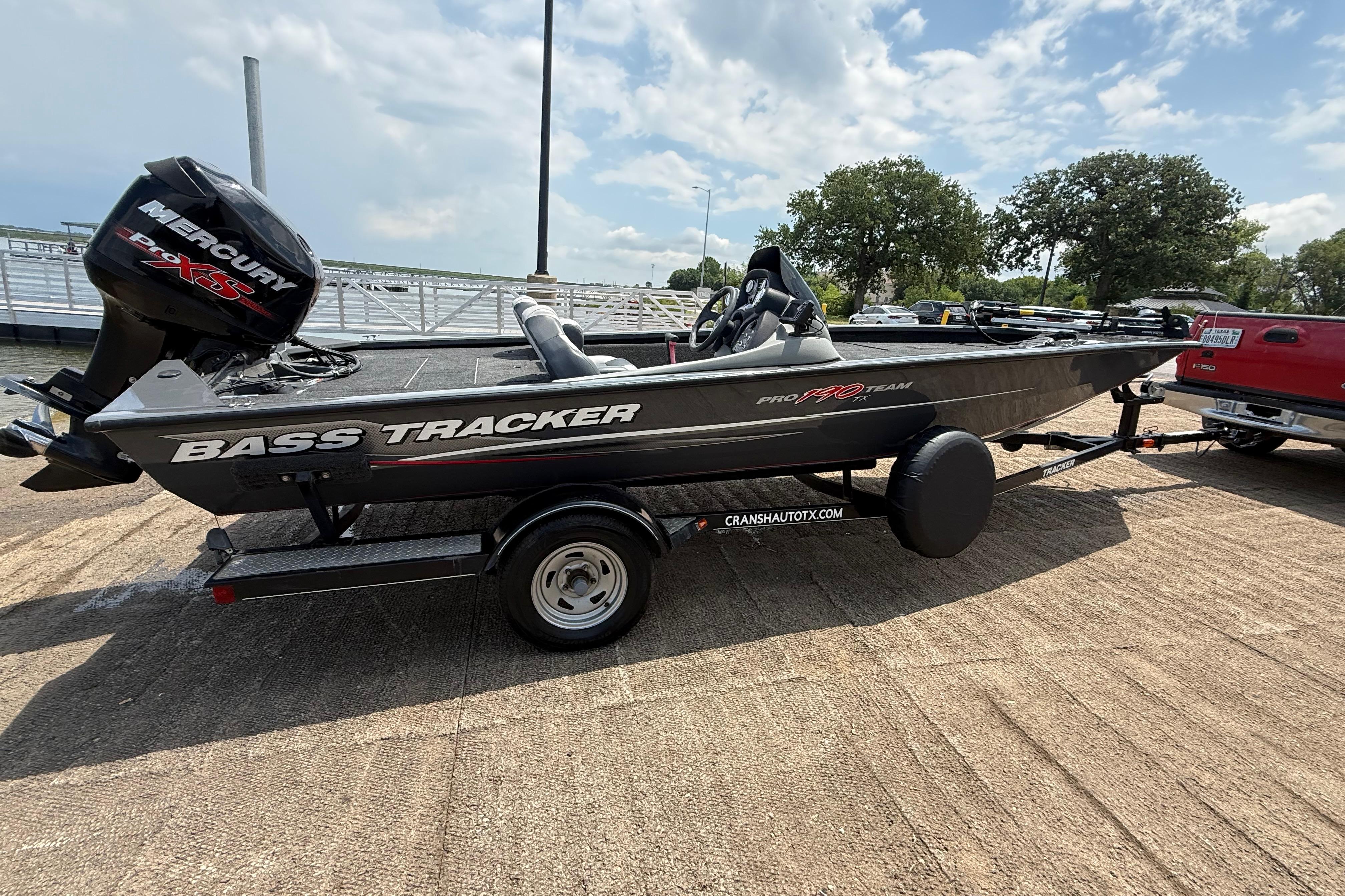2015 Tracker Pro Team 190 TX bass boat on trailer, parked near a dock.