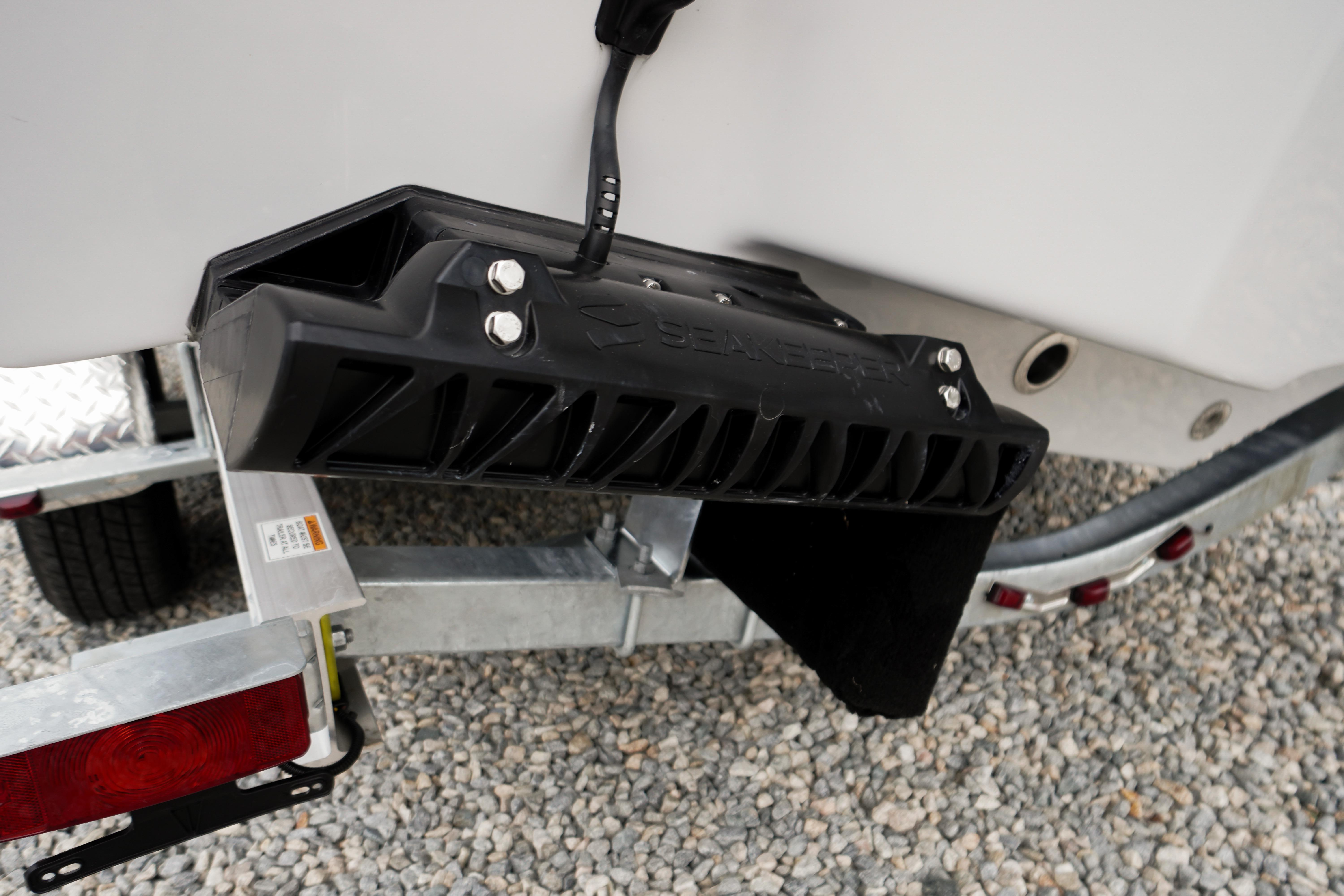 Close-up of a 2026 Tidewater 232 SS boat trailer hitch on gravel.