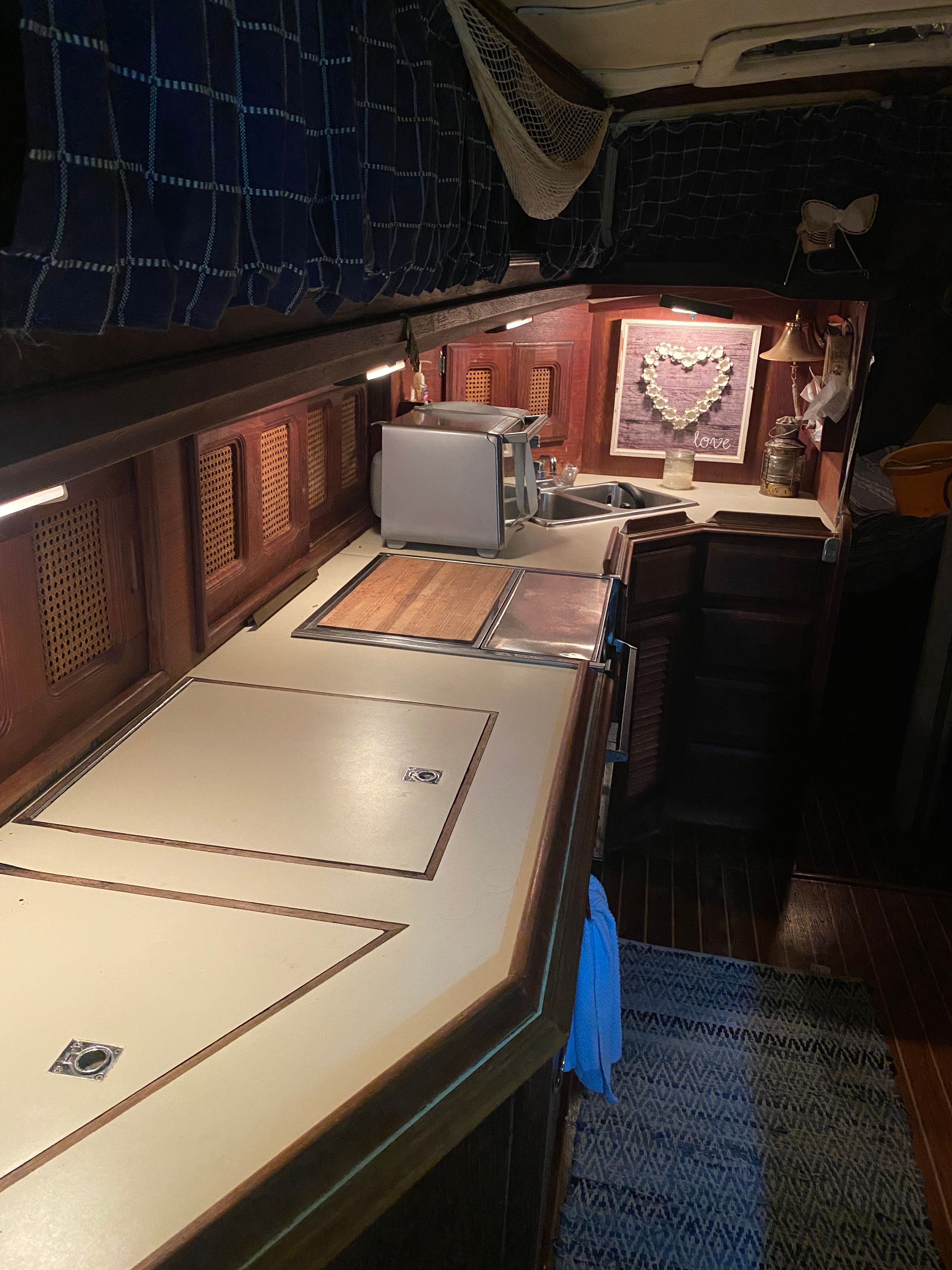 Interior of a 1983 Islander Freeport with wooden cabinetry and a kitchenette.