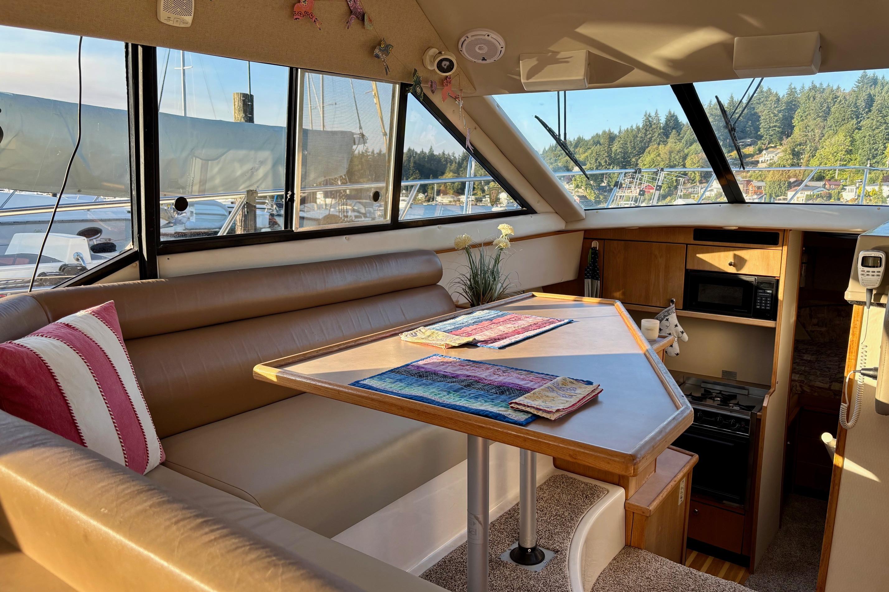 1998 Bayliner 3388 Command Bridge Motoryacht interior with dining area and kitchen amenities.