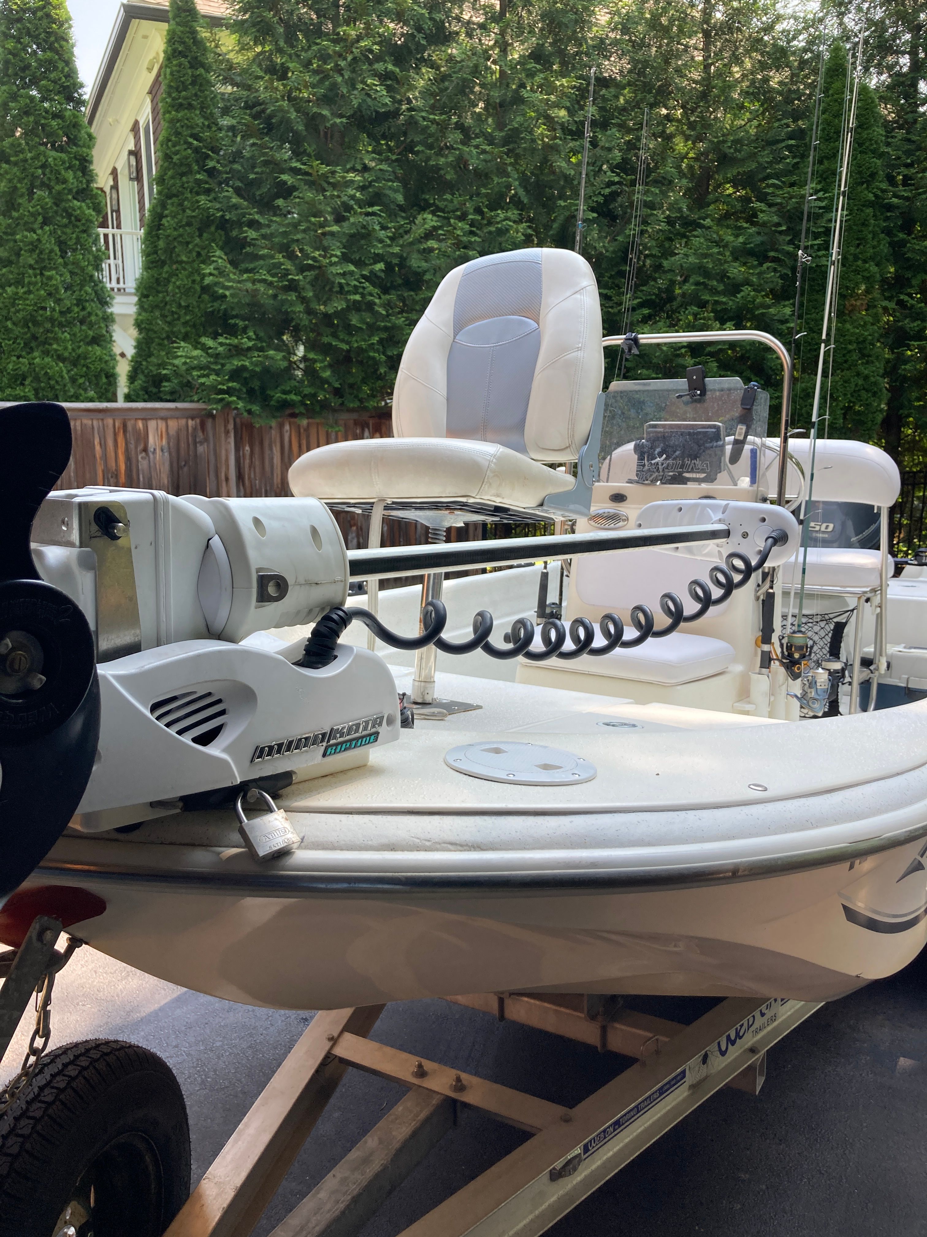 A 2012 Carolina Skiff JVX16CC on a trailer, surrounded by trees.