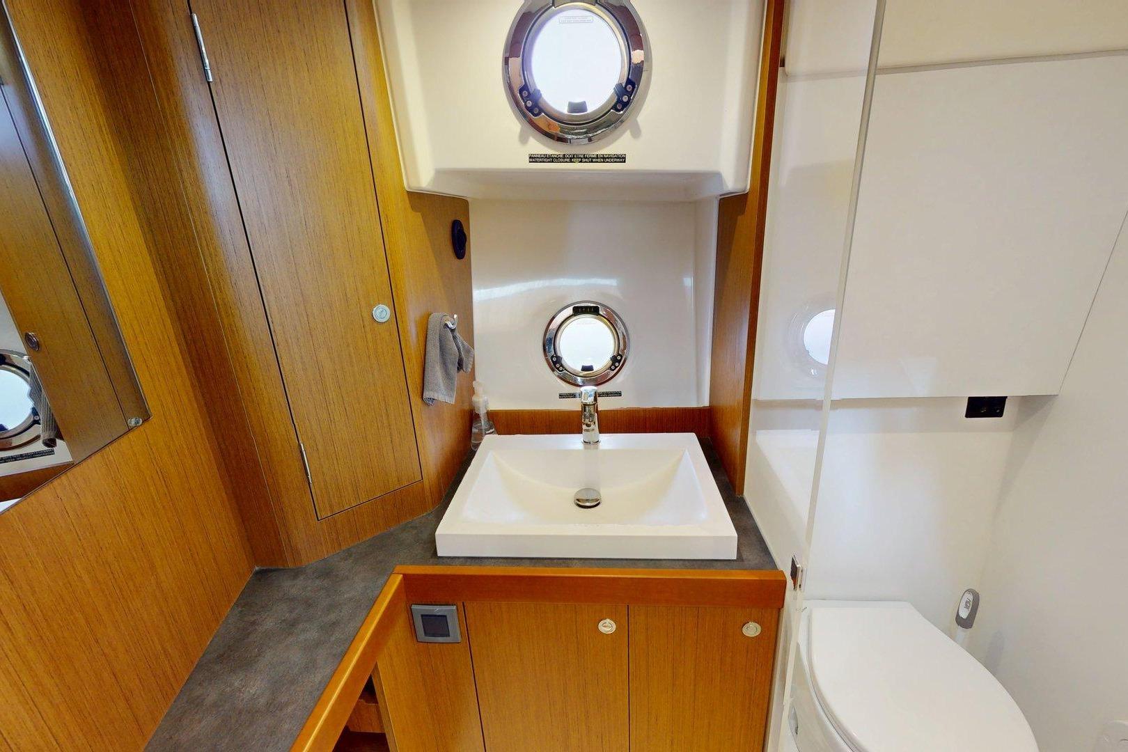 Bathroom interior of 2021 Beneteau Swift Trawler 35 with sink and porthole window.