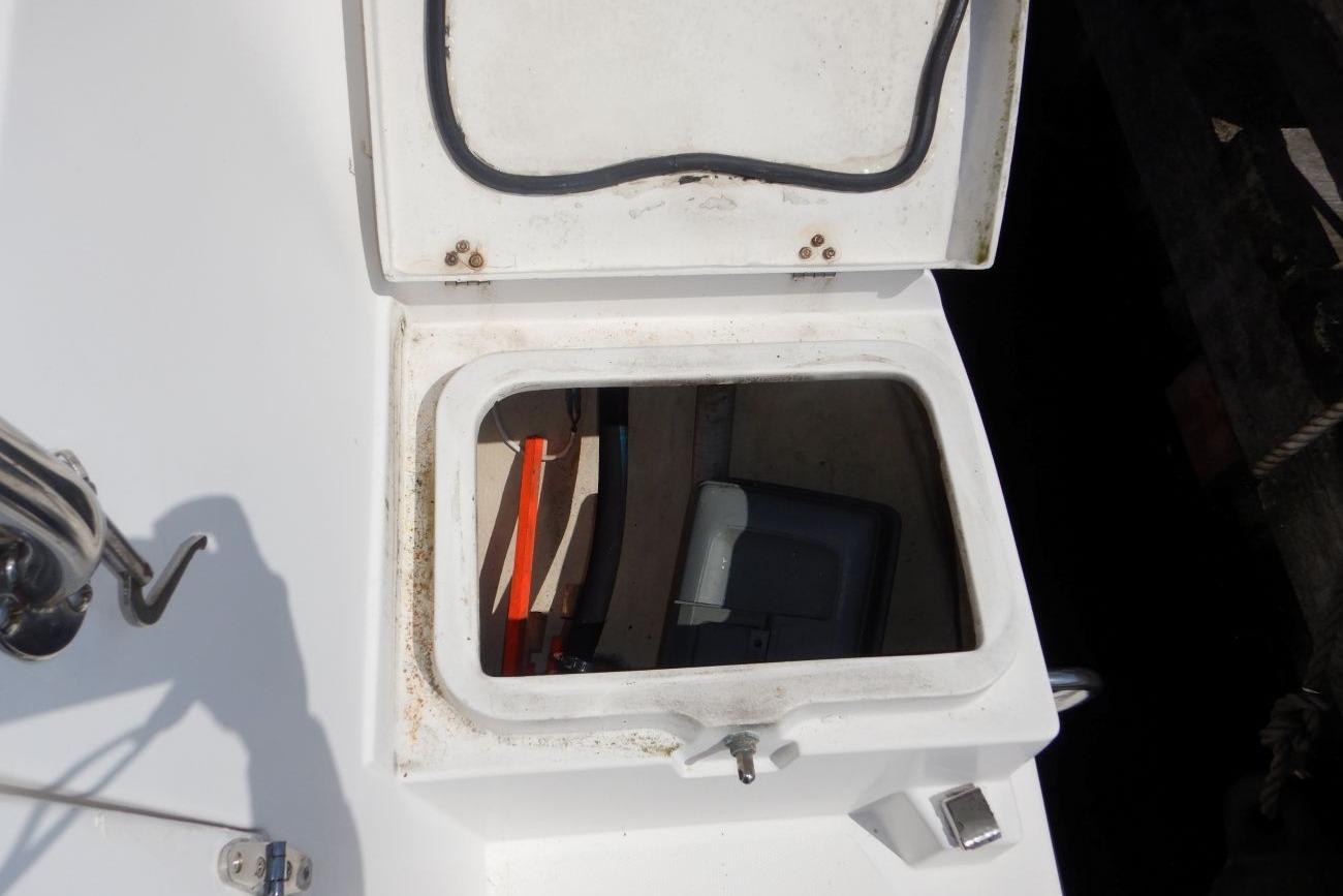 Open hatch on 2001 Hunter 320 sailboat deck, revealing storage compartment.