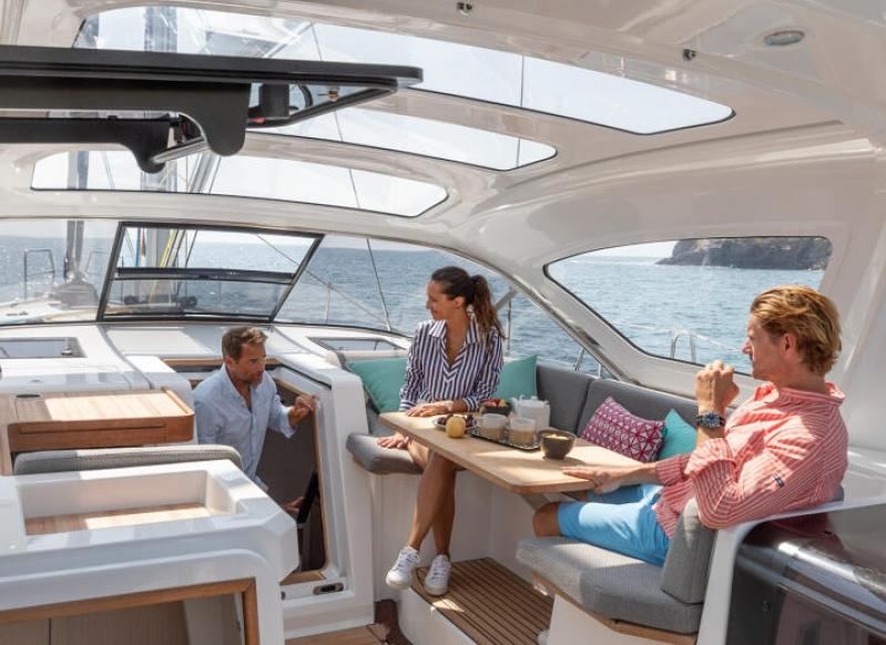 2024 Jeanneau 55 yacht interior with people enjoying a meal at sea.