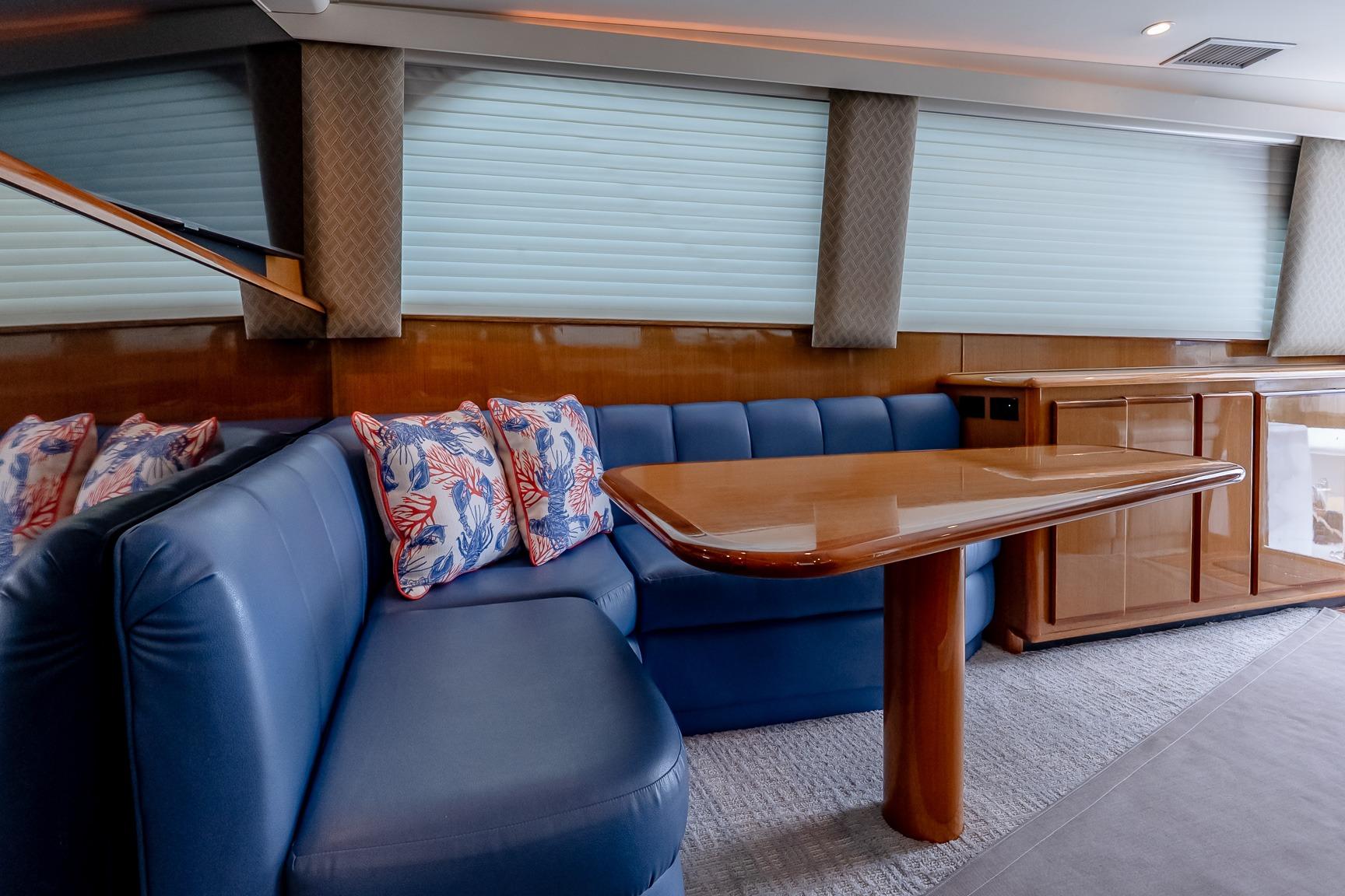 Luxurious interior of a 2000 Viking 50' Convertible yacht with blue seating and wooden table.