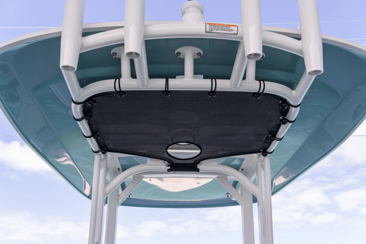 View of a Boston Whaler 25DA T-top from below, featuring a blue underside and rod holders.