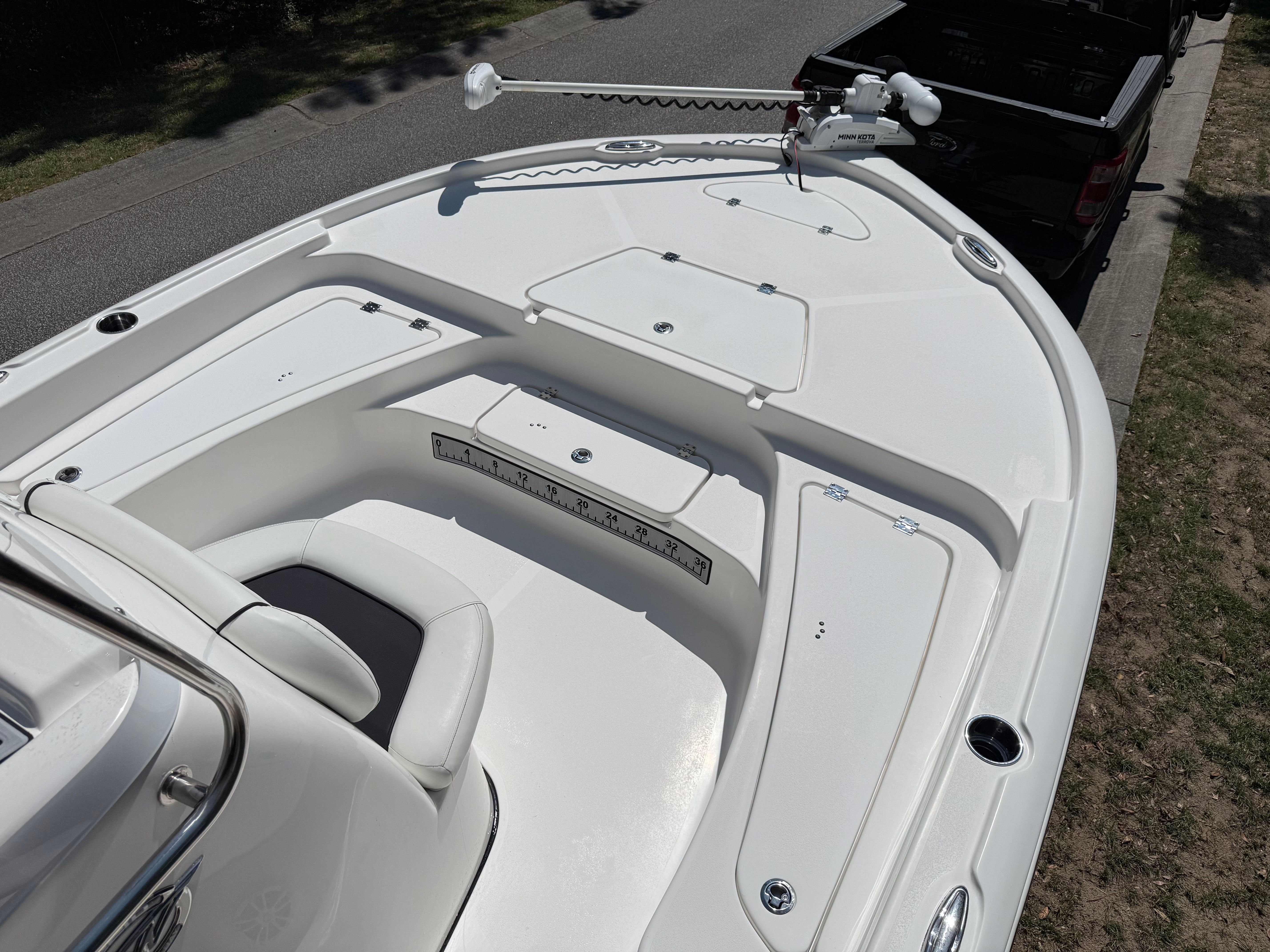 The boat features a spacious bow deck with storage compartments and seating.
