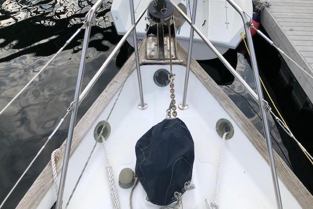 Bow of 1988 Pacific Seacraft 34 sailboat with anchor chain and ropes.