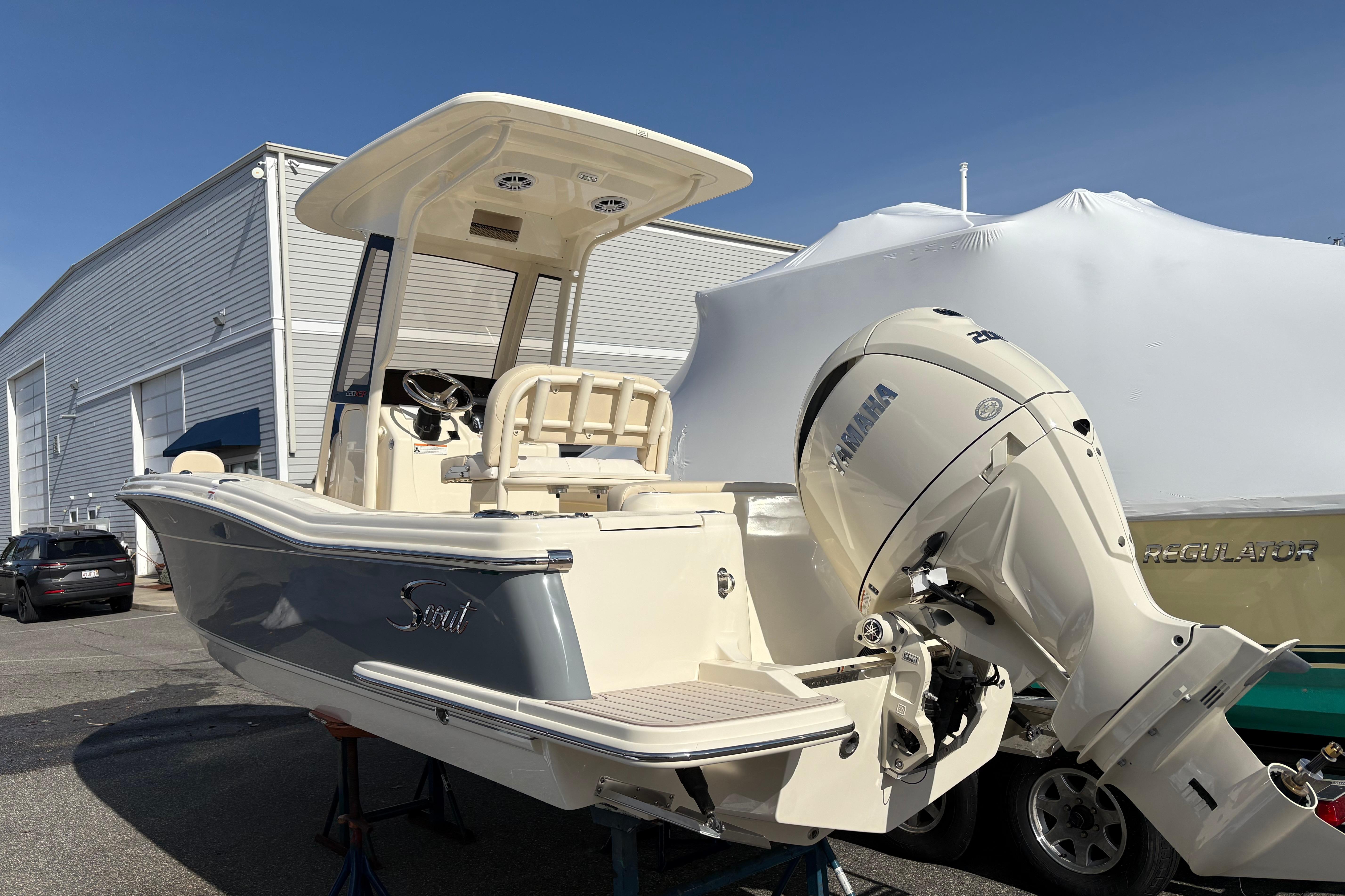 2026 Scout 220 XSF boat with Yamaha engine, parked outdoors near a building.