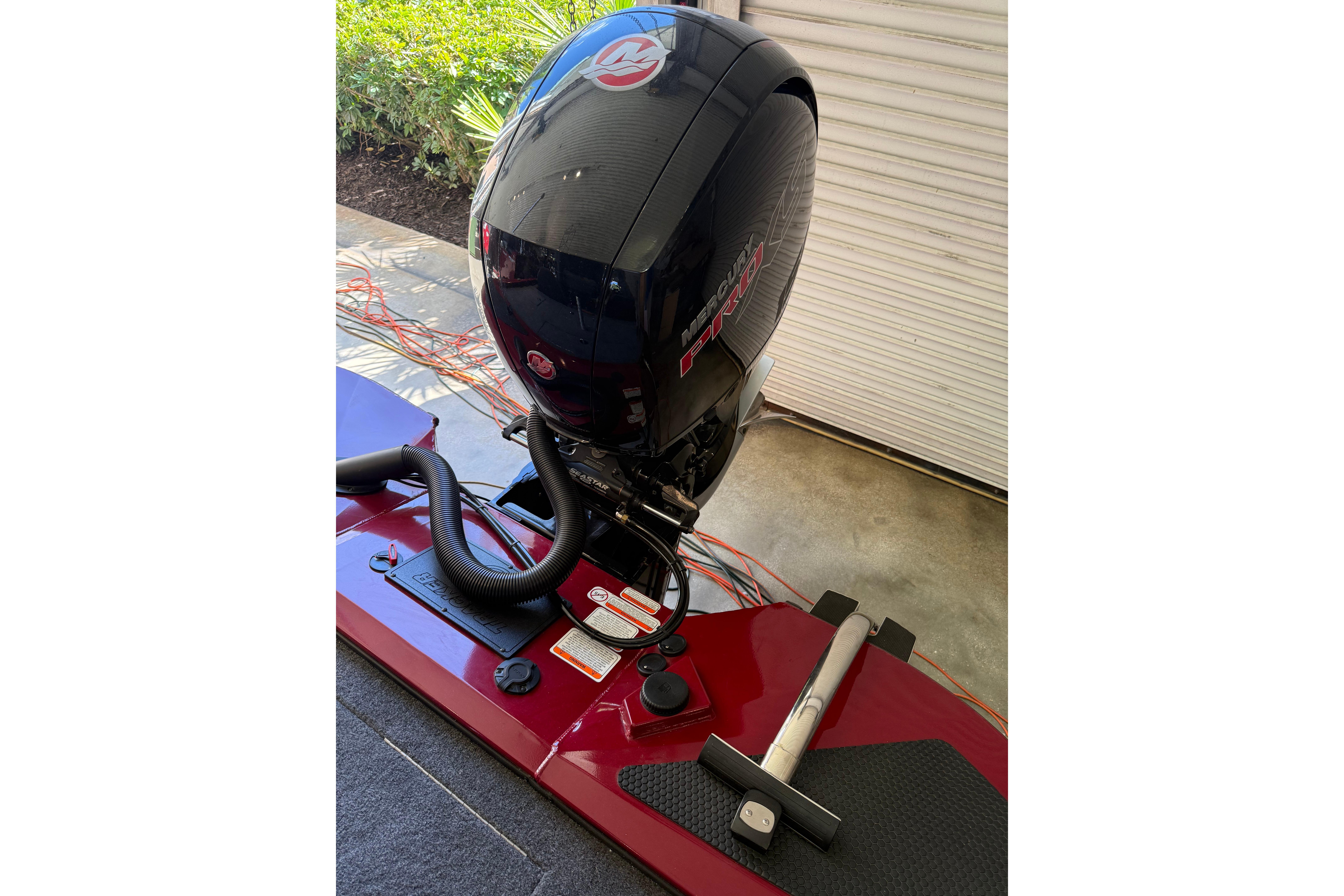 2025 Tracker Savage 215 boat with Mercury Pro XS engine in a garage setting.