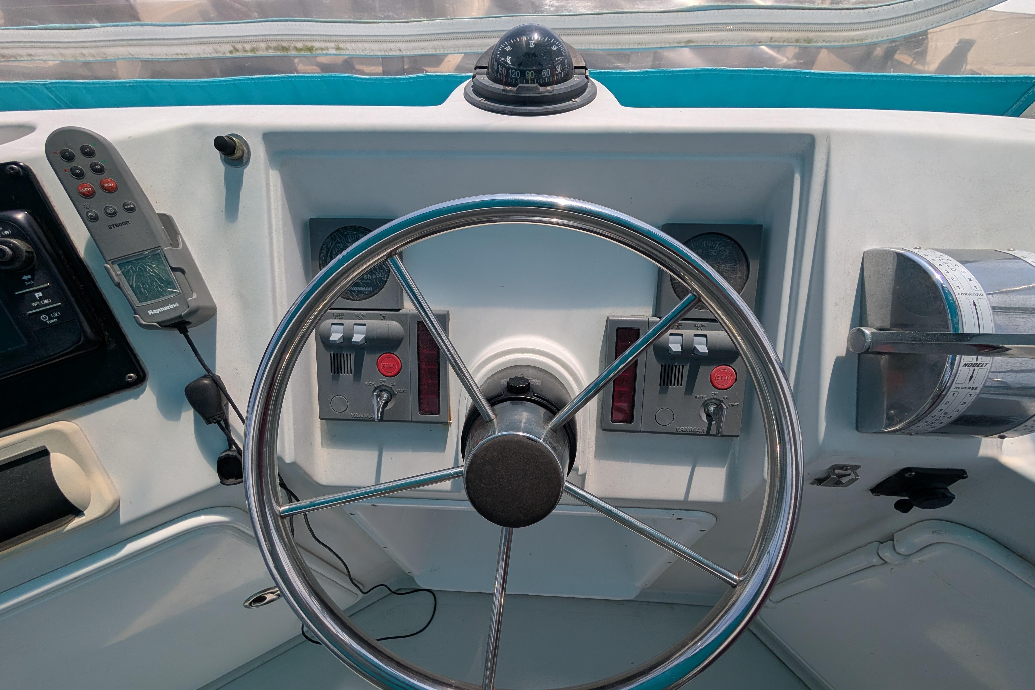 Steering wheel and controls of a 2004 PDQ 34 Powercat boat cockpit.