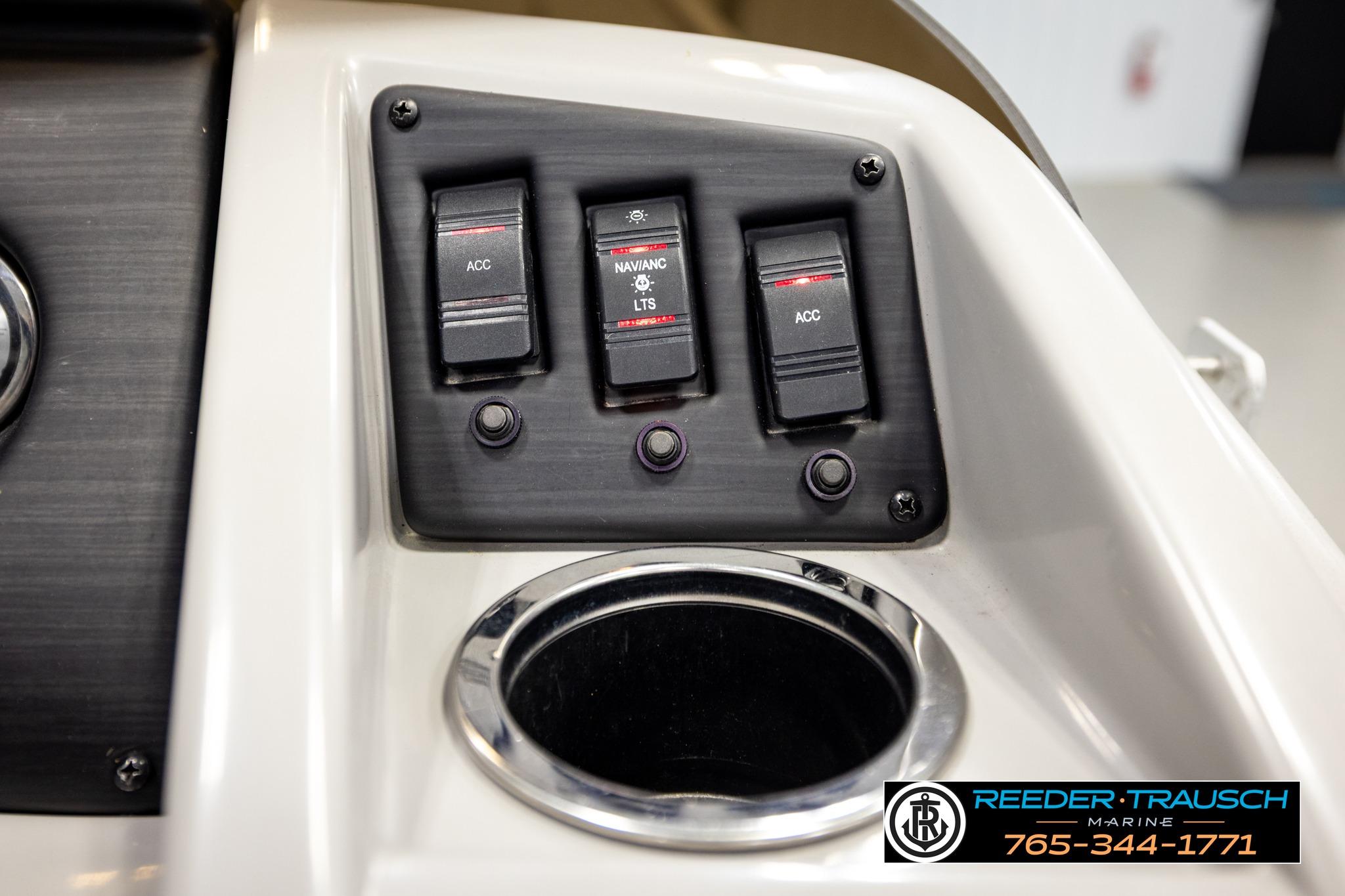 Control panel of a 2021 Bennington 20 SV boat with switches and cup holder.