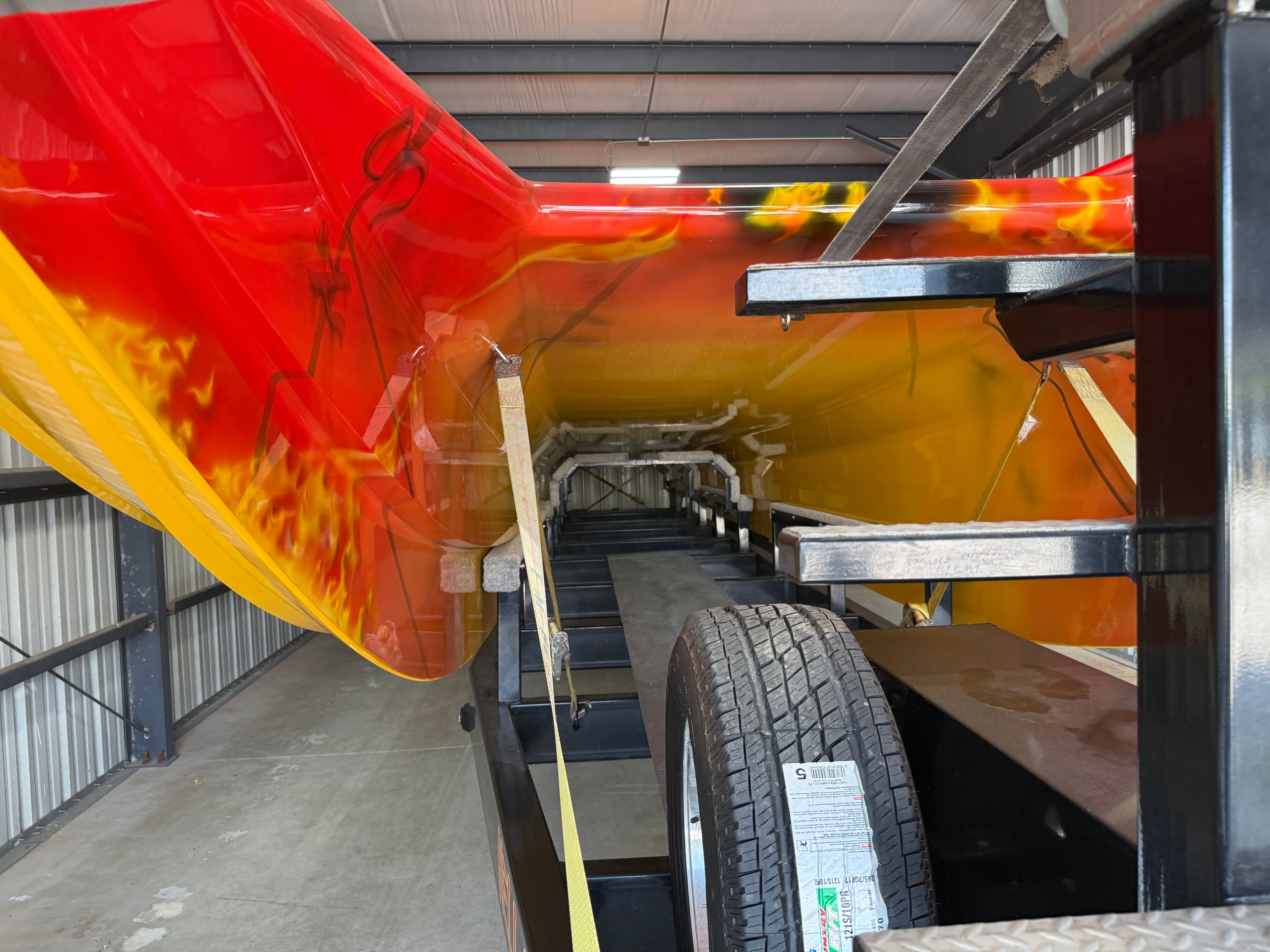 A 2010 MTI CAT with striking red and yellow design on a trailer in a warehouse.