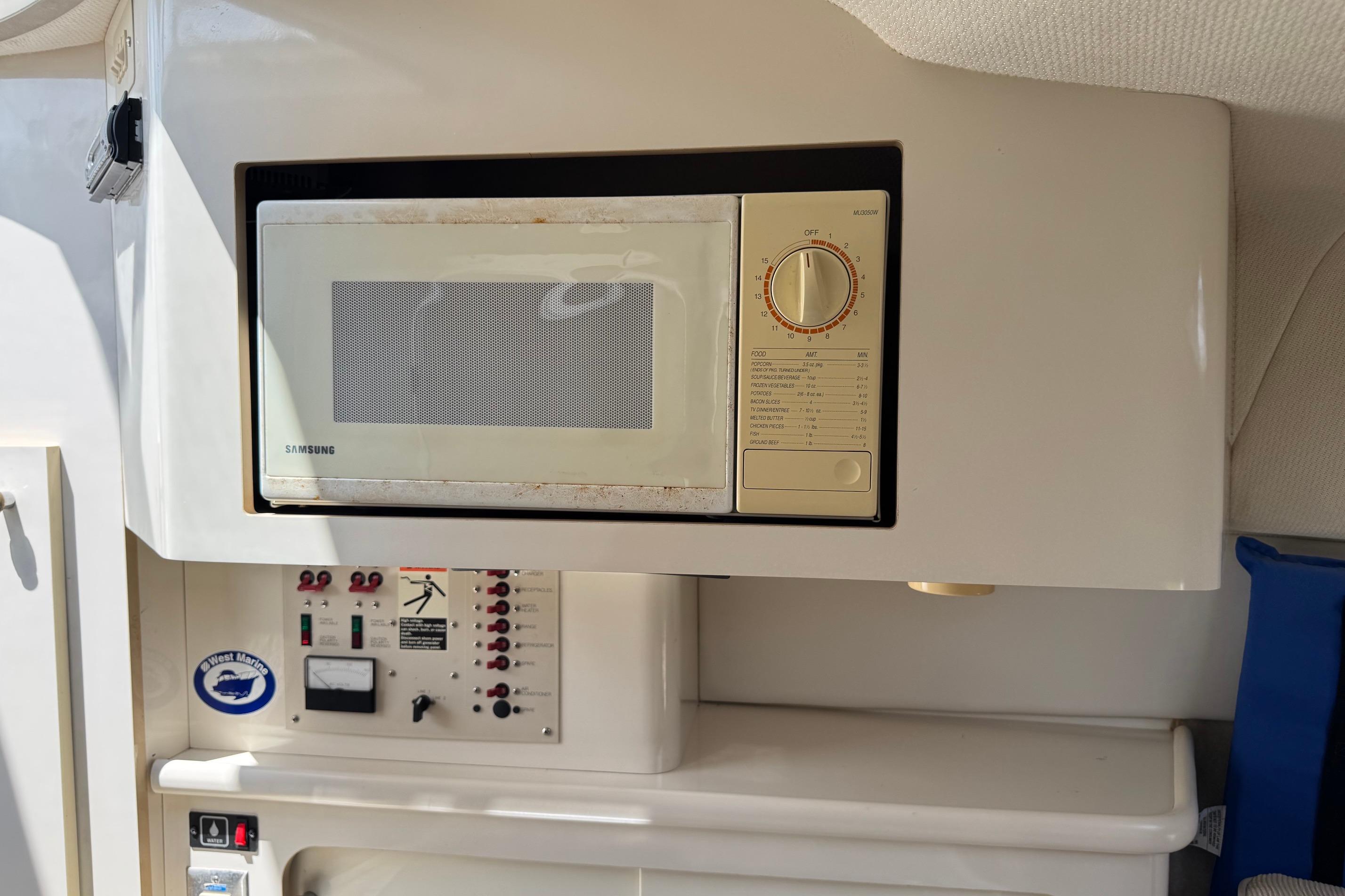 Microwave and control panel inside a 2000 Maxum 2400 SCR boat cabin.
