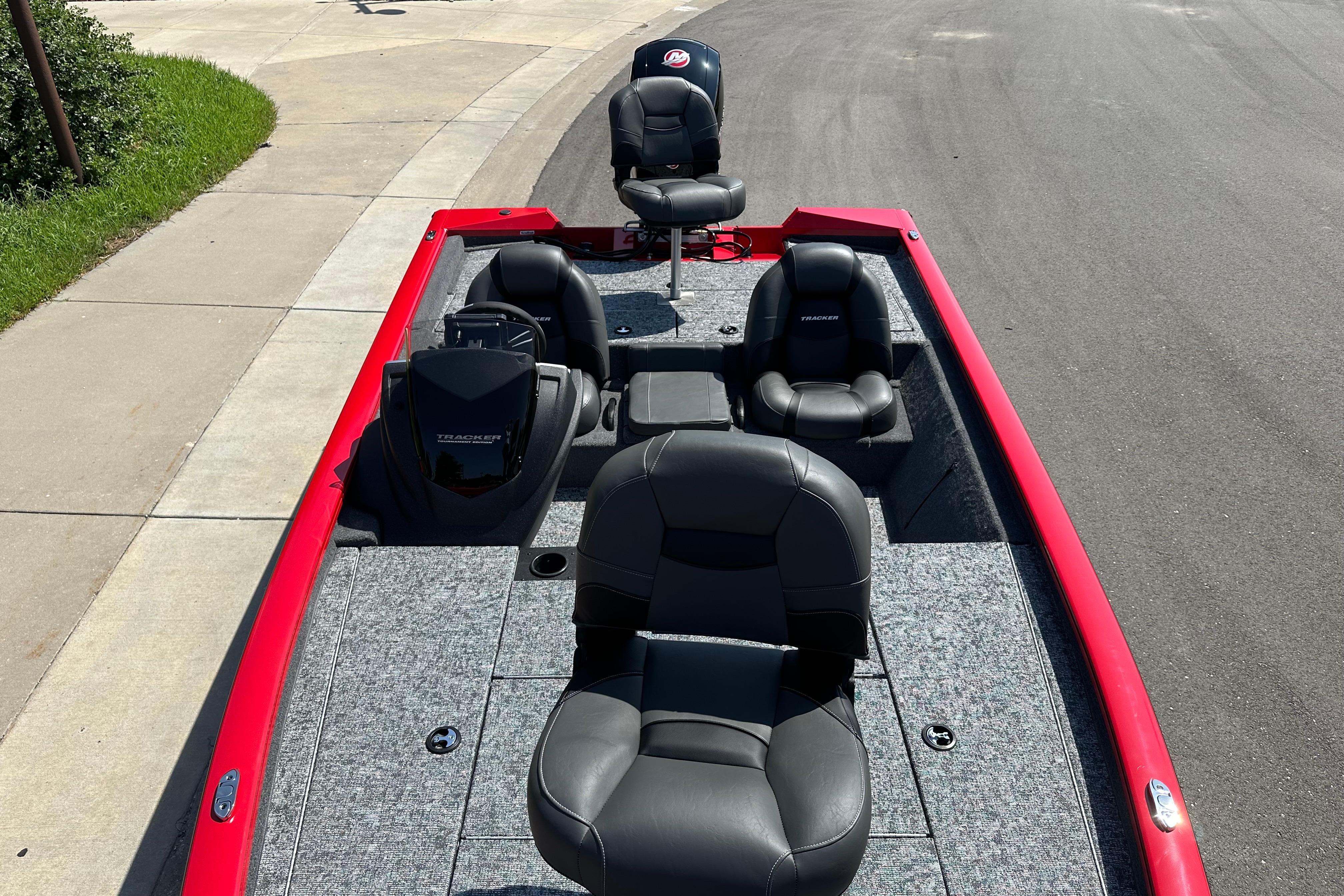 2026 Tracker Pro Team 195 boat with red trim and black seating on a paved surface.