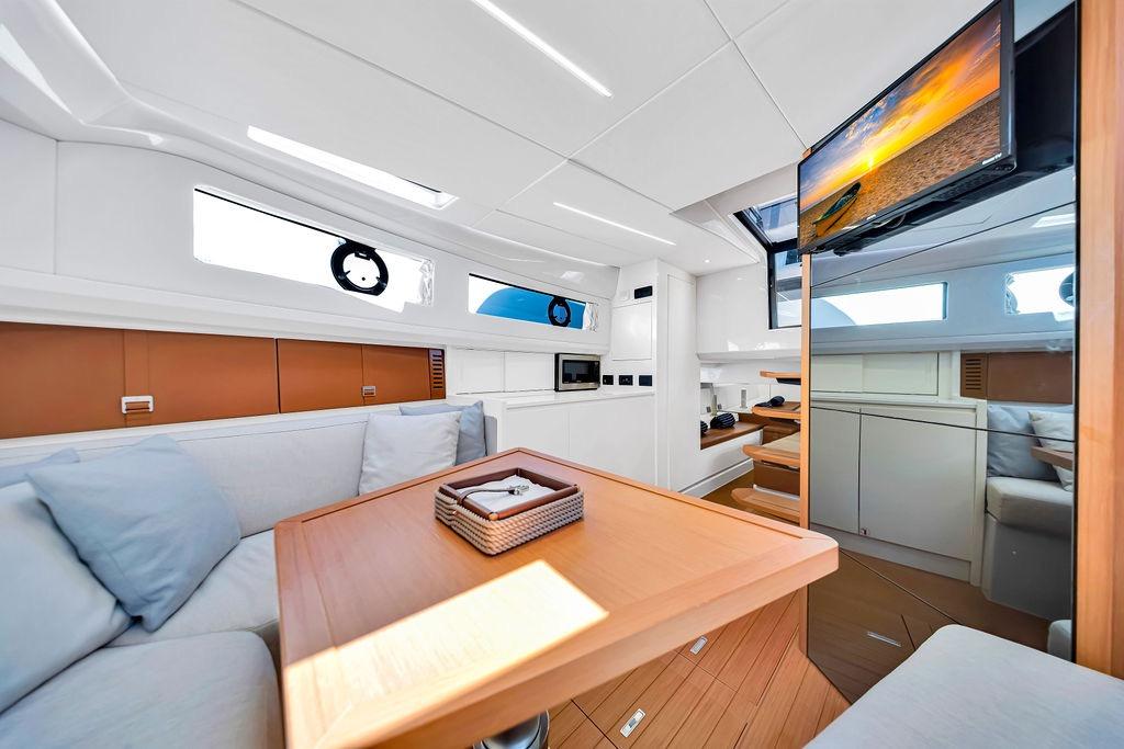 Luxurious interior of 2021 Bluegame BG 42 yacht with modern furnishings and a mounted TV.