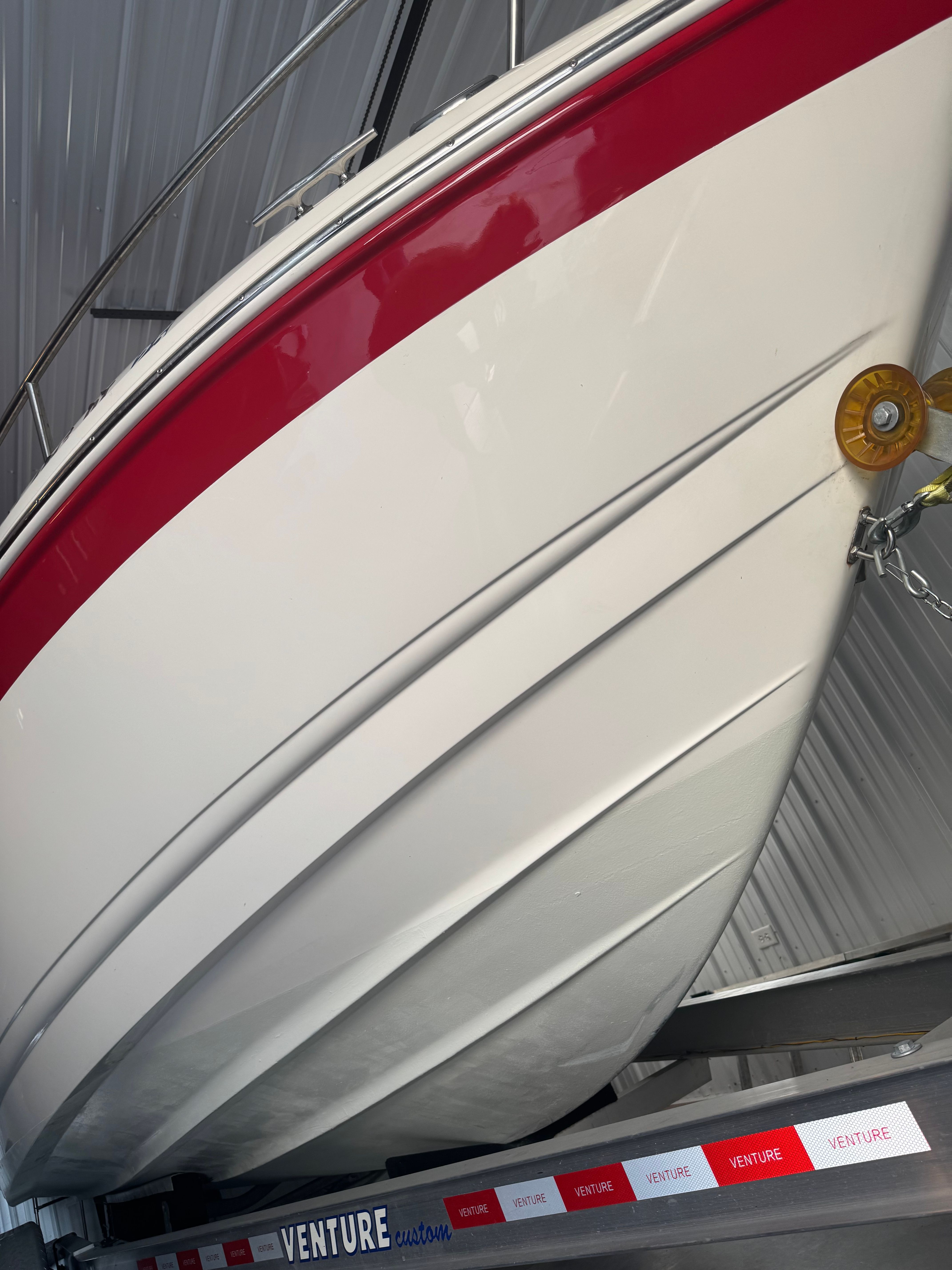 A 2006 Chaparral 235 SSi boat with a red stripe, stored on a trailer.