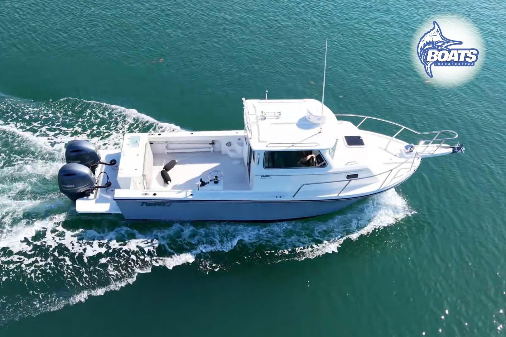 2021 Parker 2520 XLD Sport Cabin boat cruising on clear blue water.