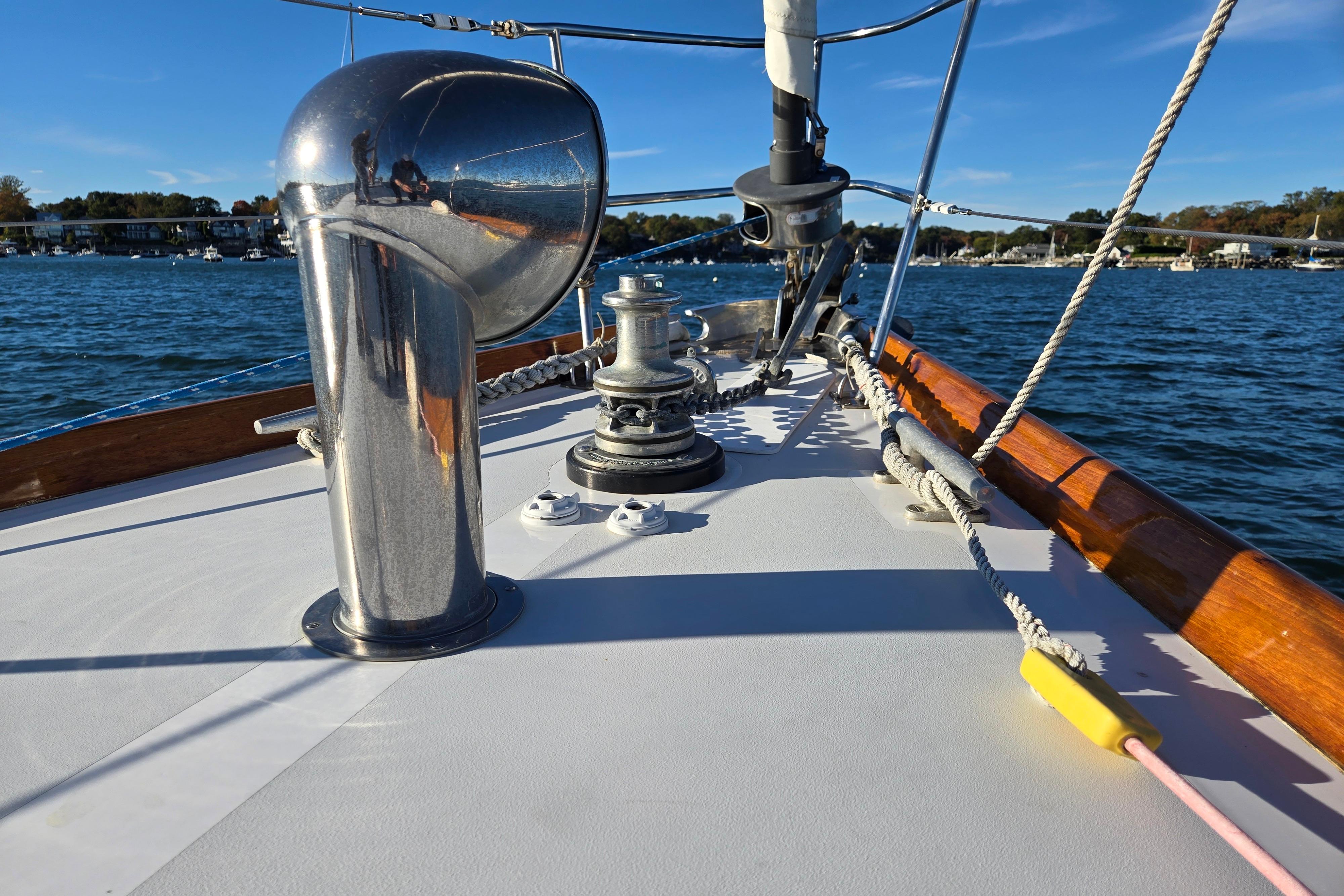 Hinckley Bermuda 40 sailboat deck with winch and ropes, sailing on a sunny day.