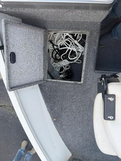 An open storage compartment on a boat with ropes inside.
