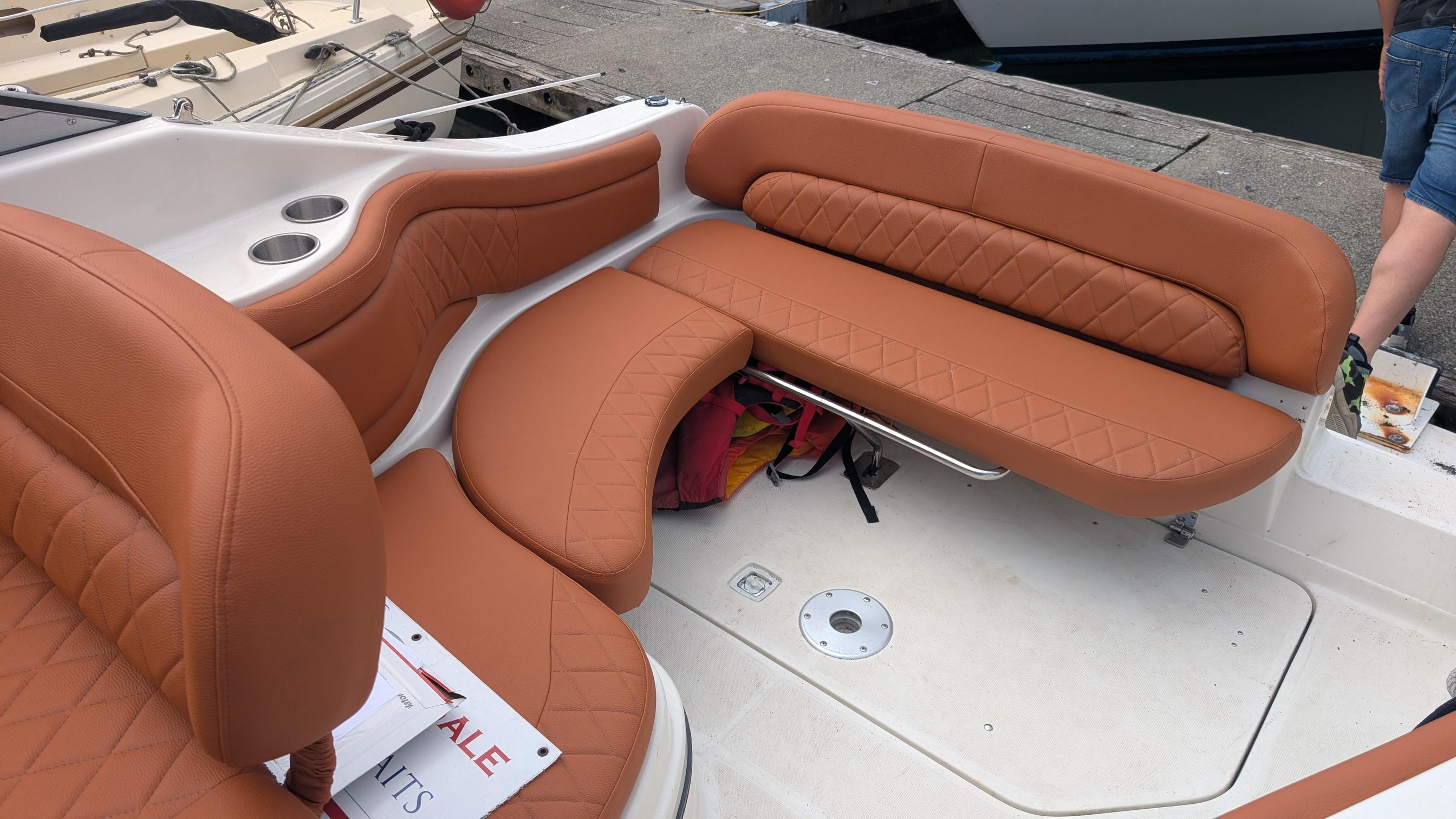 2002 Regal 2465 Commodore boat with tan leather seating and cup holders.