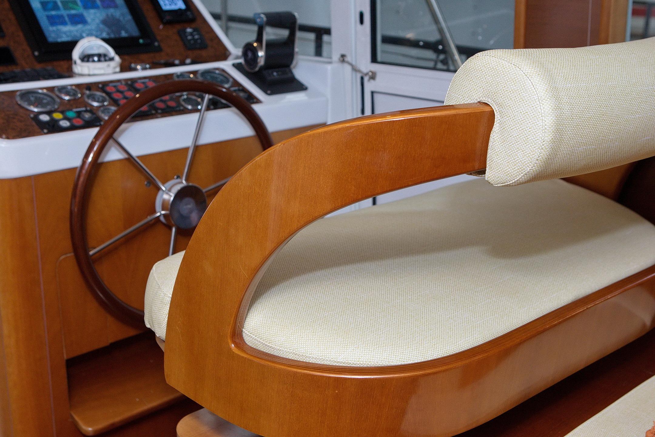 2004 Beneteau Swift Trawler 42 helm with wooden steering wheel and cushioned seat.