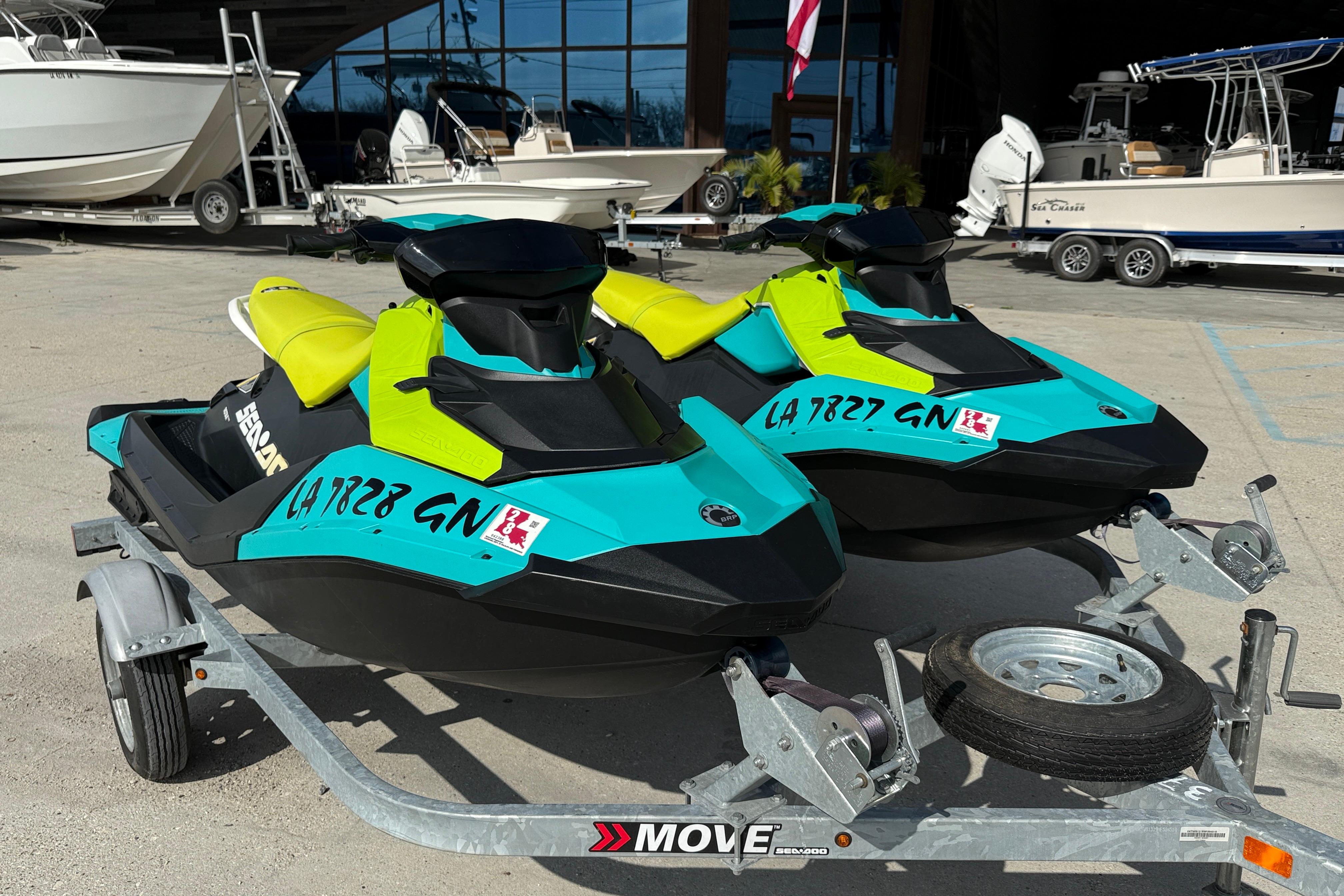 2022 Sea-Doo Spark 3up jet skis on a trailer, vibrant colors, parked near boats.