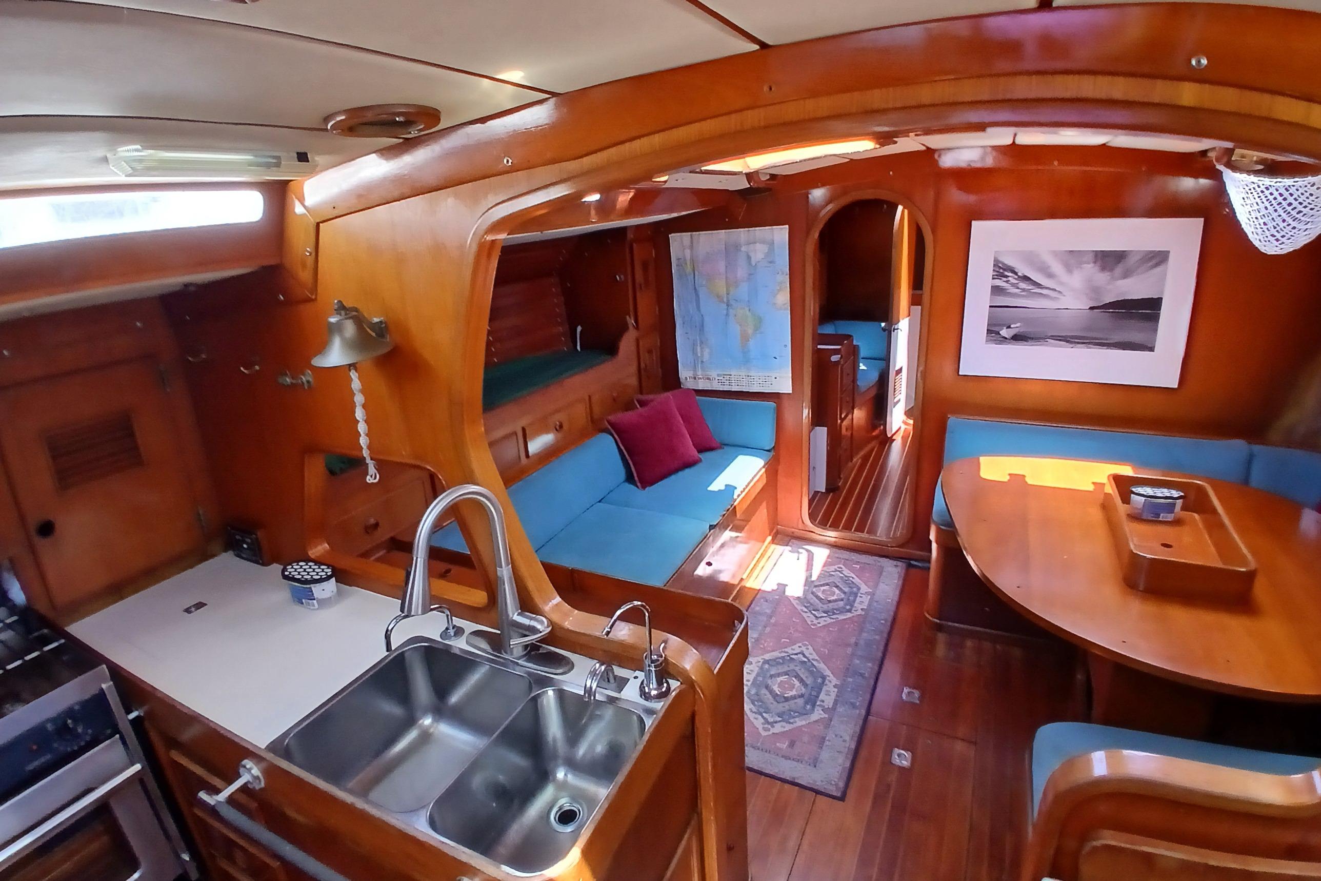 Interior of a 1981 SKYE 51 yacht with wooden decor, cozy seating, and nautical accents.
