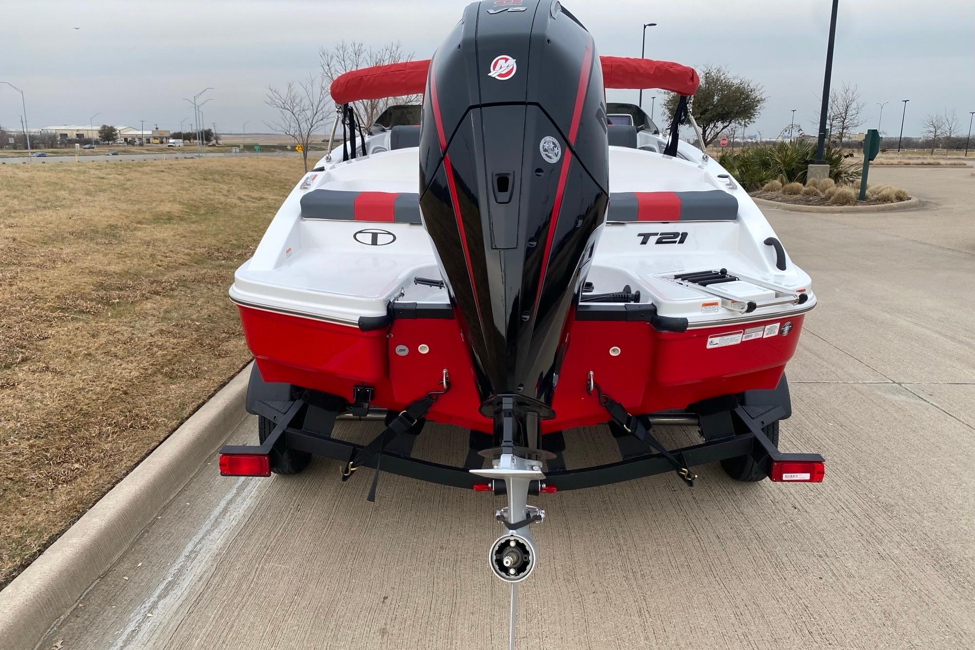 2026 Tahoe T21 boat with outboard motor on trailer, parked on roadside.