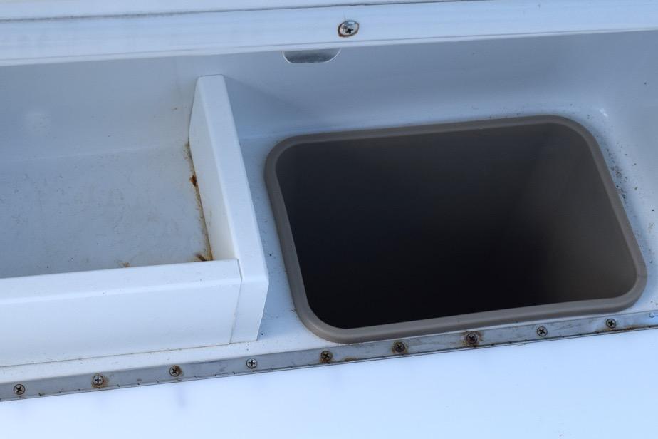 Storage compartment on a 2006 Cobalt 240 boat, featuring a clean, white interior.