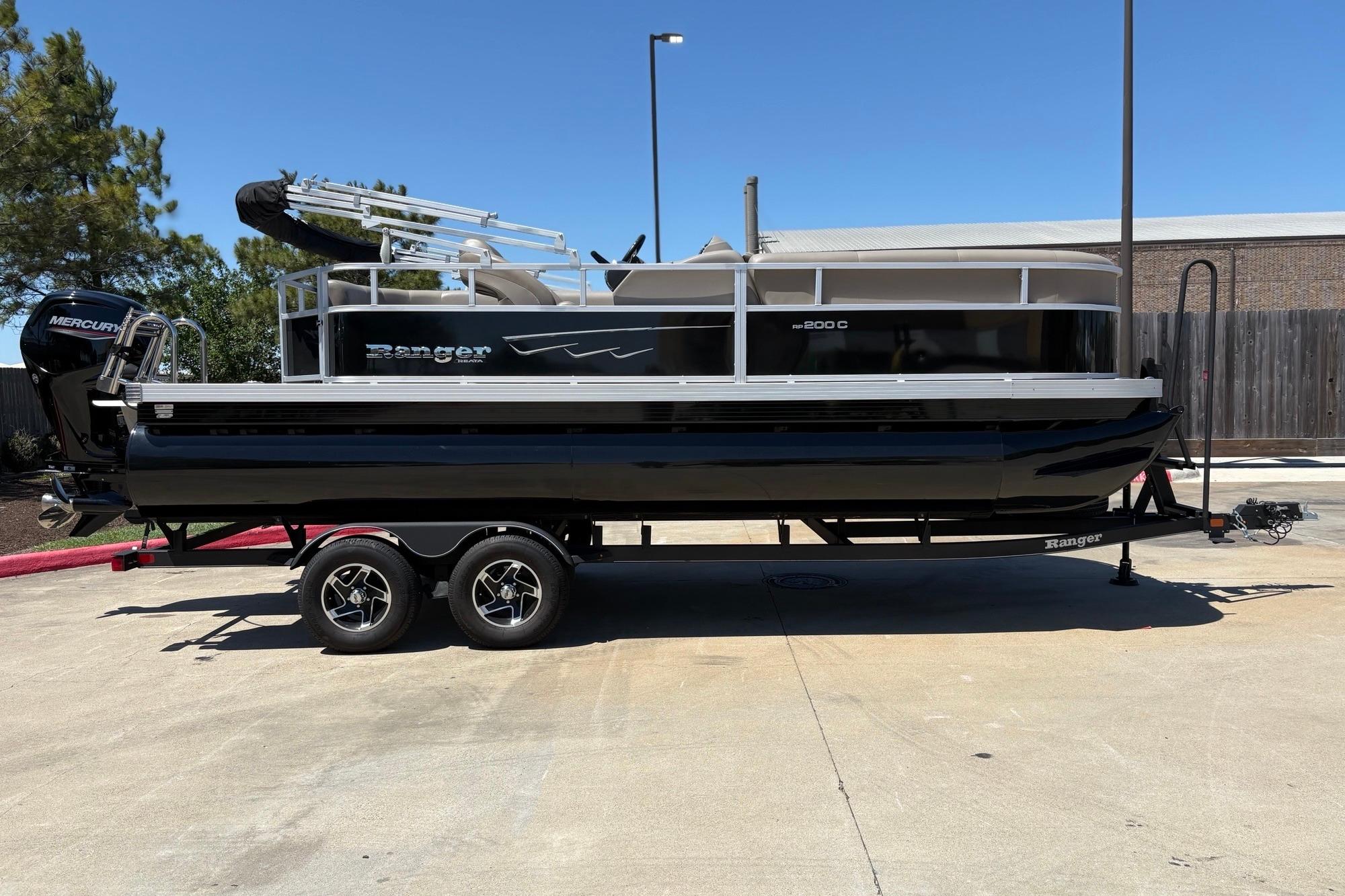 2024 Ranger Reata 200C pontoon boat on trailer, parked outdoors.