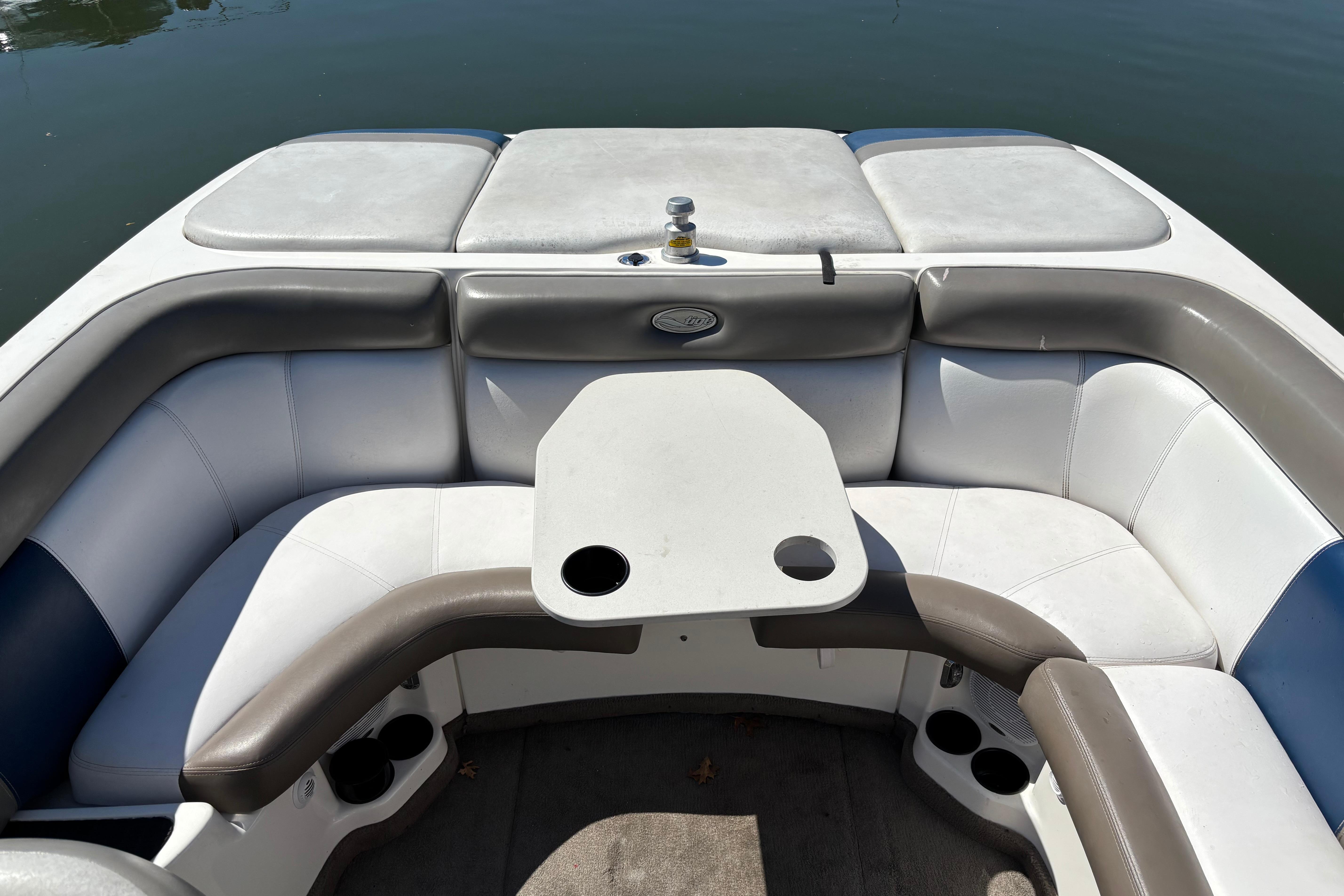 2004 Tigé 22V Limited Edition boat interior with cushioned seating and table on calm water.