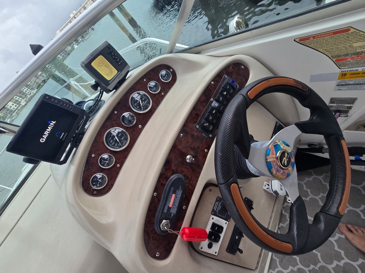 The cockpit of a Sea Ray Sundancer 260 with modern instruments and a Garmin navigation system.