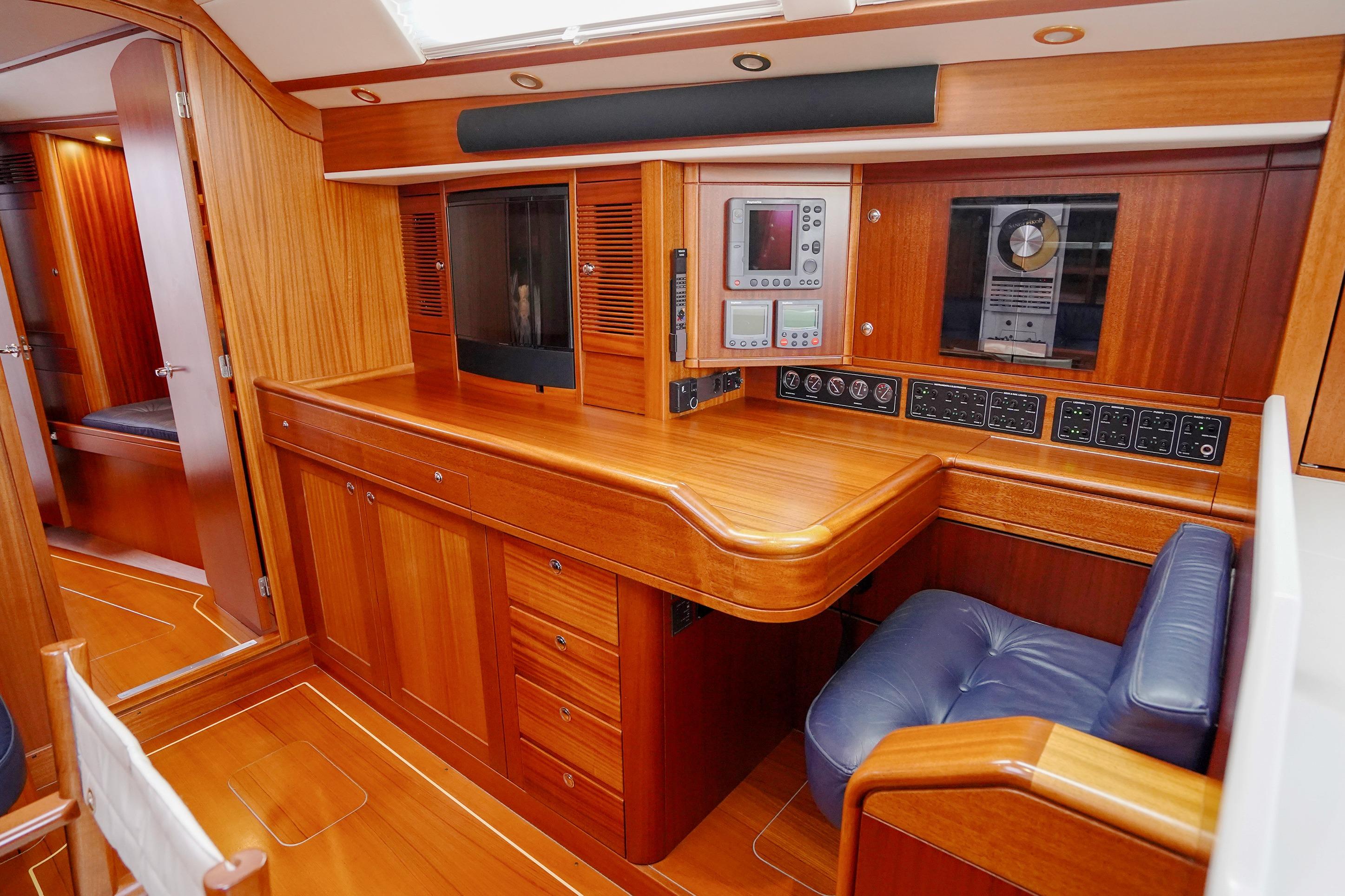 Luxurious interior of 2000 Sweden Yachts 45, featuring wooden cabinetry and navigation equipment.