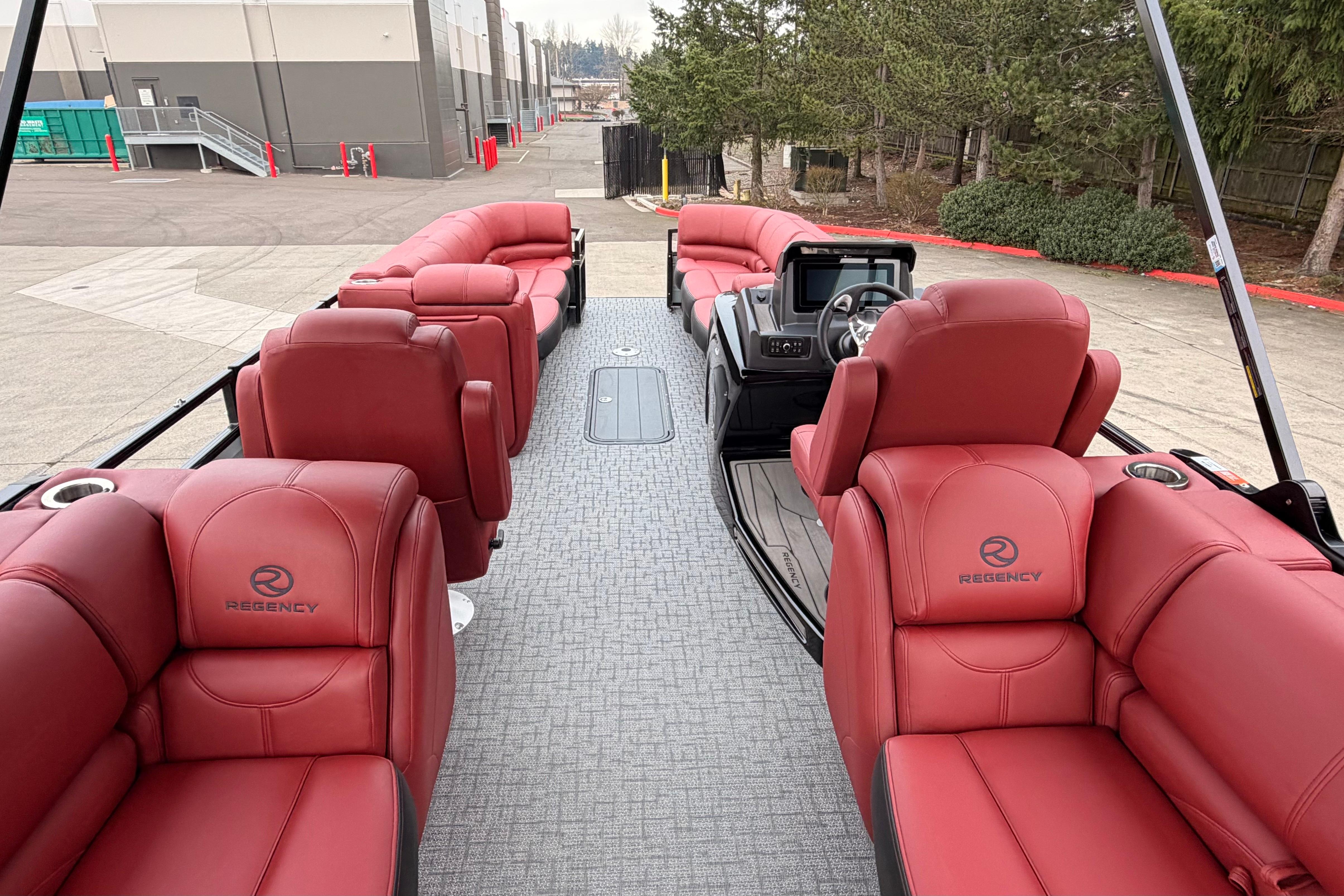 Luxurious 2026 Regency 250 DL pontoon boat with red leather seating and modern dashboard.